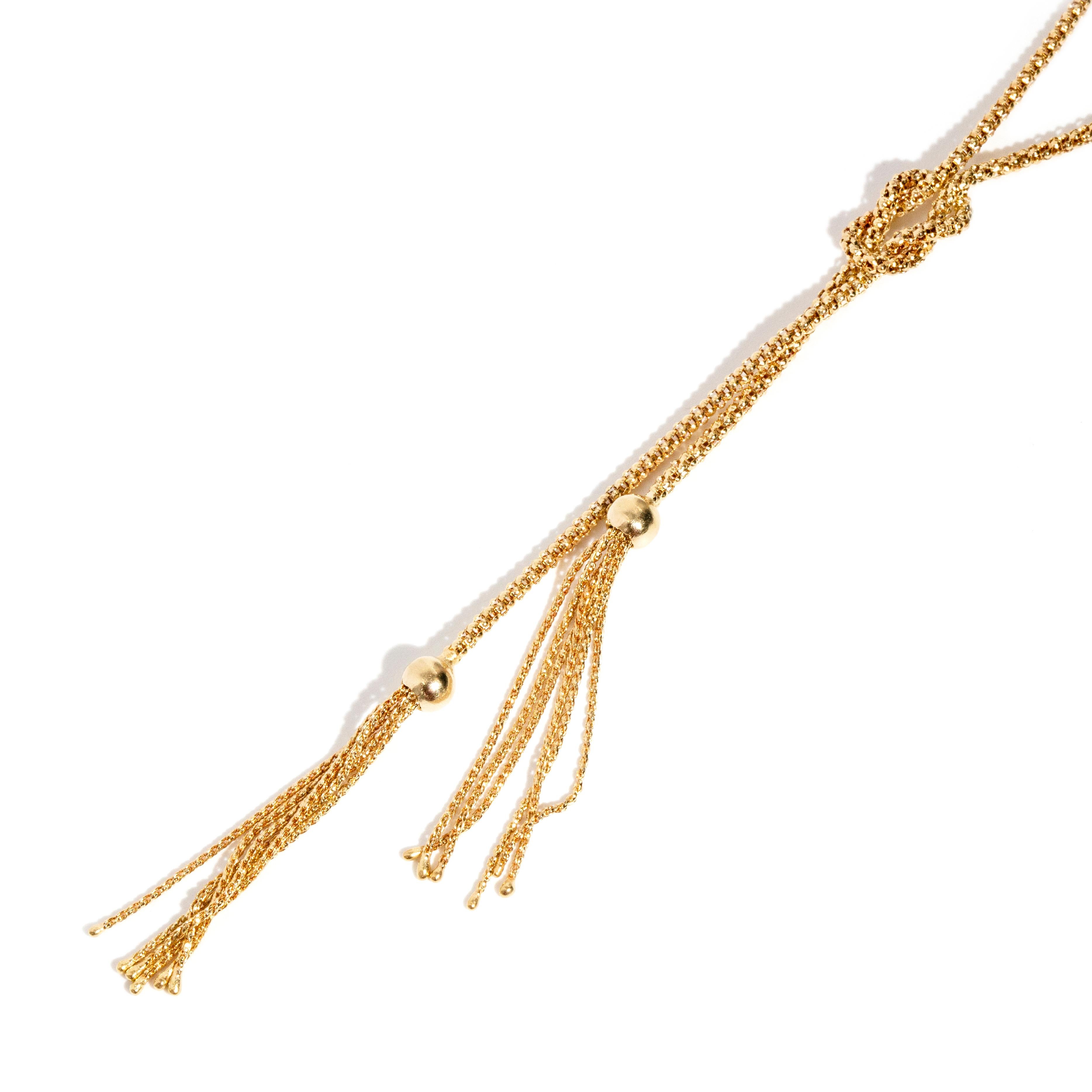 Crafted in 18 carat yellow gold, this elegant 1990s lariat necklace with lovely tassle endings brought together in a graceful knot. This wonderful piece, named The Delphine Necklace, is easily modifiable into whatever knot you prefer and looks