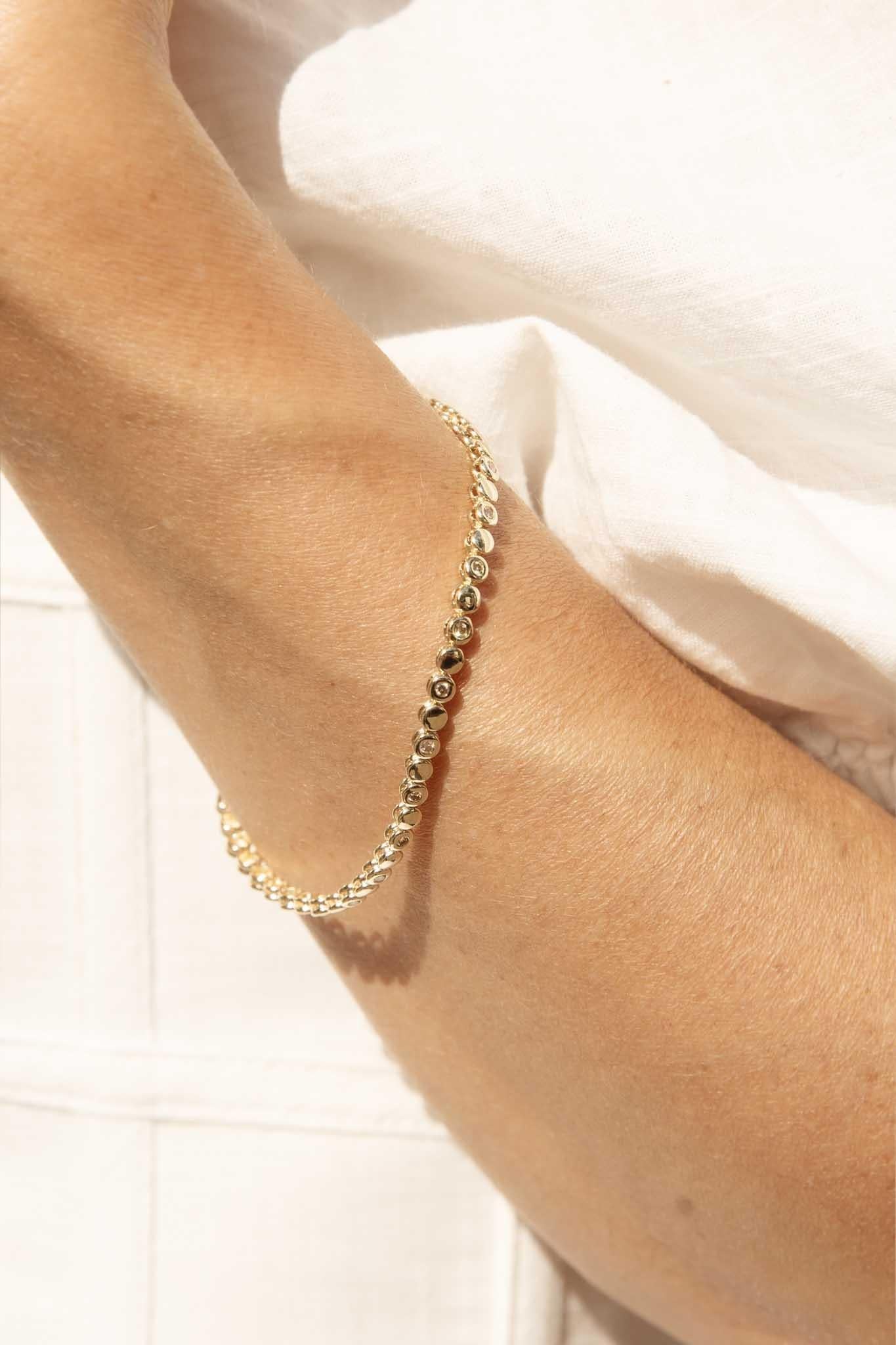 Une éblouissante cascade de diamants orne cet exquis bracelet de tennis en or jaune 9 carats. Chaque pierre brillante, une minuscule étoile, est méticuleusement sertie sur une seule rangée, créant un spectacle envoûtant de lumière et d'éclat.
