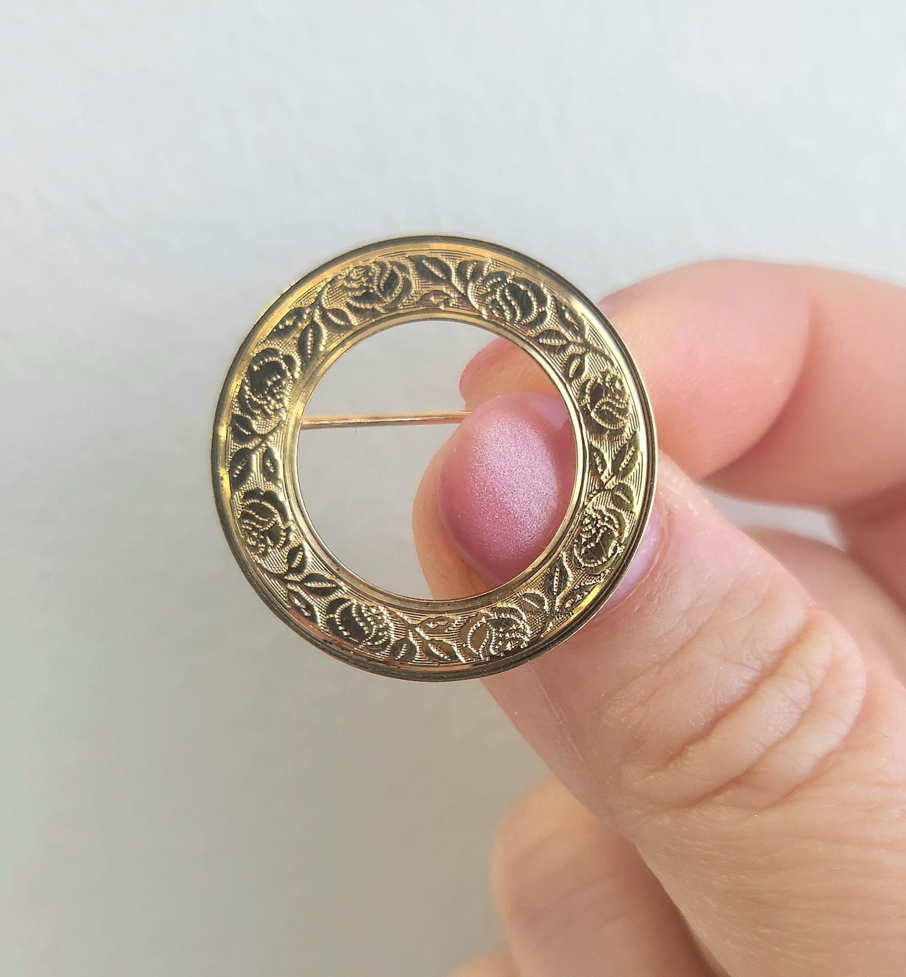 This lovely vintage brooch features a delicate circle of engraved roses and leaves in warm 14K yellow gold. Beautifully detailed with a romantic, nature-inspired design, it makes a timeless accent on a lapel, scarf, or chain.

Design: Engraved roses