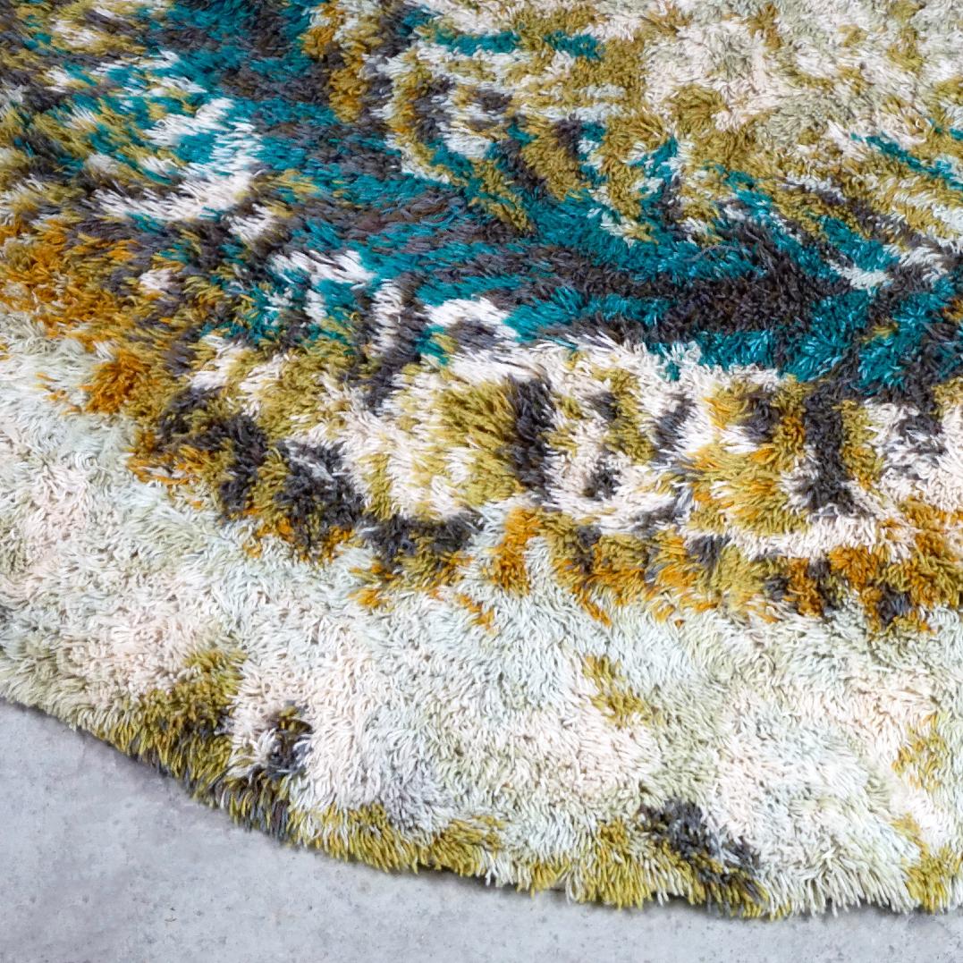 Large Circular Danish modern rya rug labeled Norsk for British carpet centre, Axminster,  England. 100% wool.   
Charming colours in creamy beige, blue and turquoise, very decorative design carpet in very good original condition without damages and