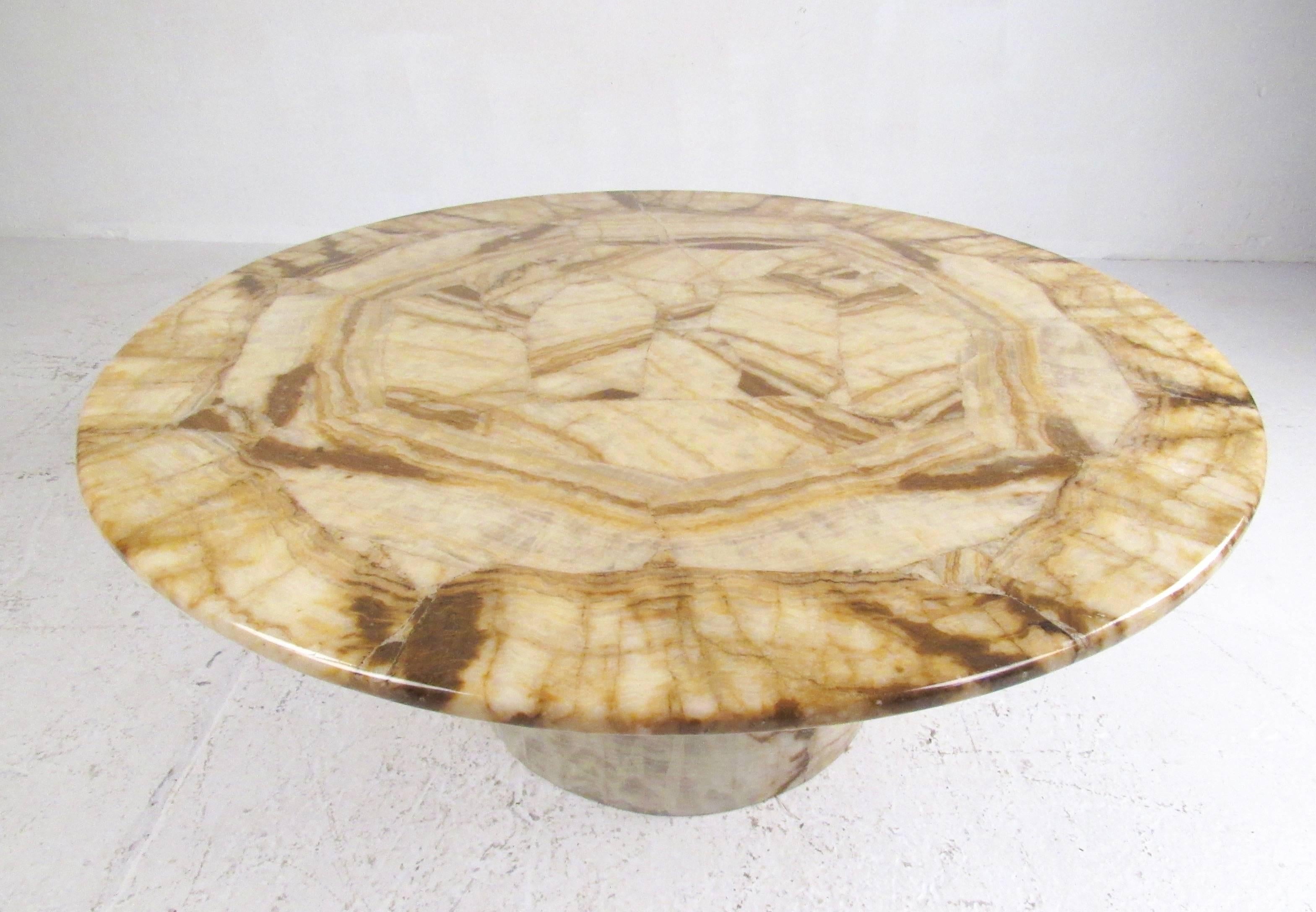 This unique vintage coffee table features a stone finish veneer over wood core. Mid-Century Modern design and 1970s palette add to the retro appeal of this circular table. Striking pedestal cocktail table for home or business seating area. Please