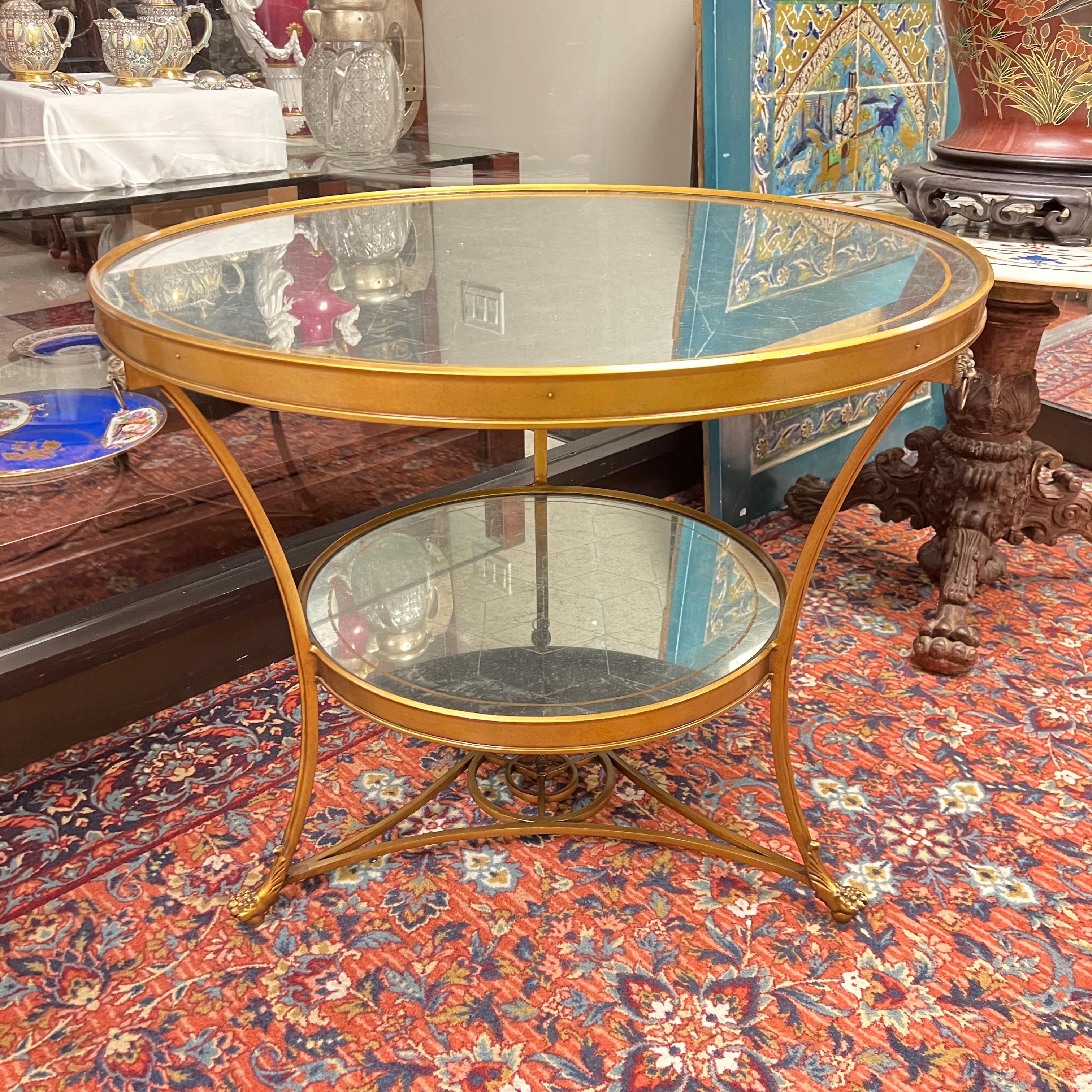 Exceptional vintage bronze tripod center table in the stylized Louis XVI style with geometric engraved mirrored top and stretcher, lion masks with rings, with lion paw feet raised on hidden brass casters.  