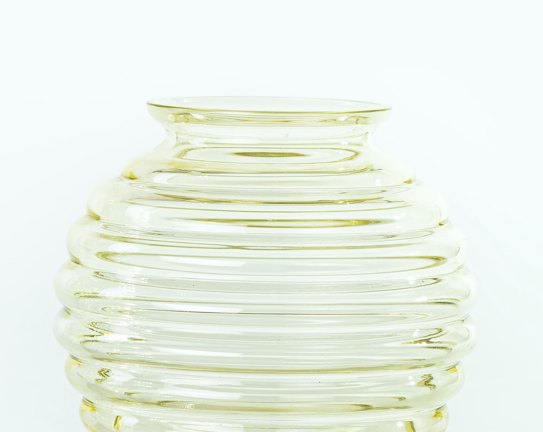 Circular vase is an original decorative object realized in Italy in the 1960s.

Beautiful little with bands detected in a yellowish glass.