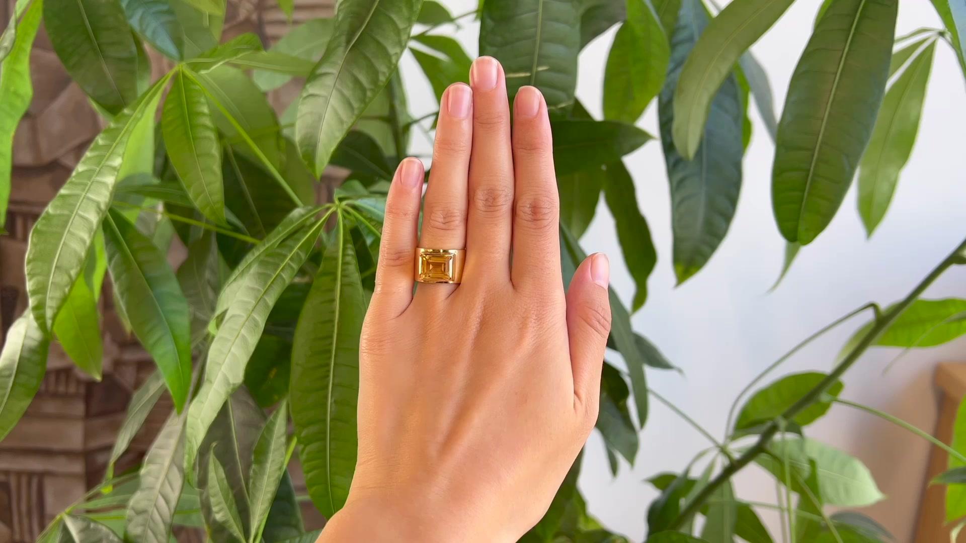 One Vintage Citrine 18 Karat Yellow Gold Cigar Band Ring. Featuring one rectangular step cut yellow citrine weighing approximately 2.65 carats. Crafted in 18 karat yellow gold with purity marks. Circa 1970. The ring is a size 5 and may be
