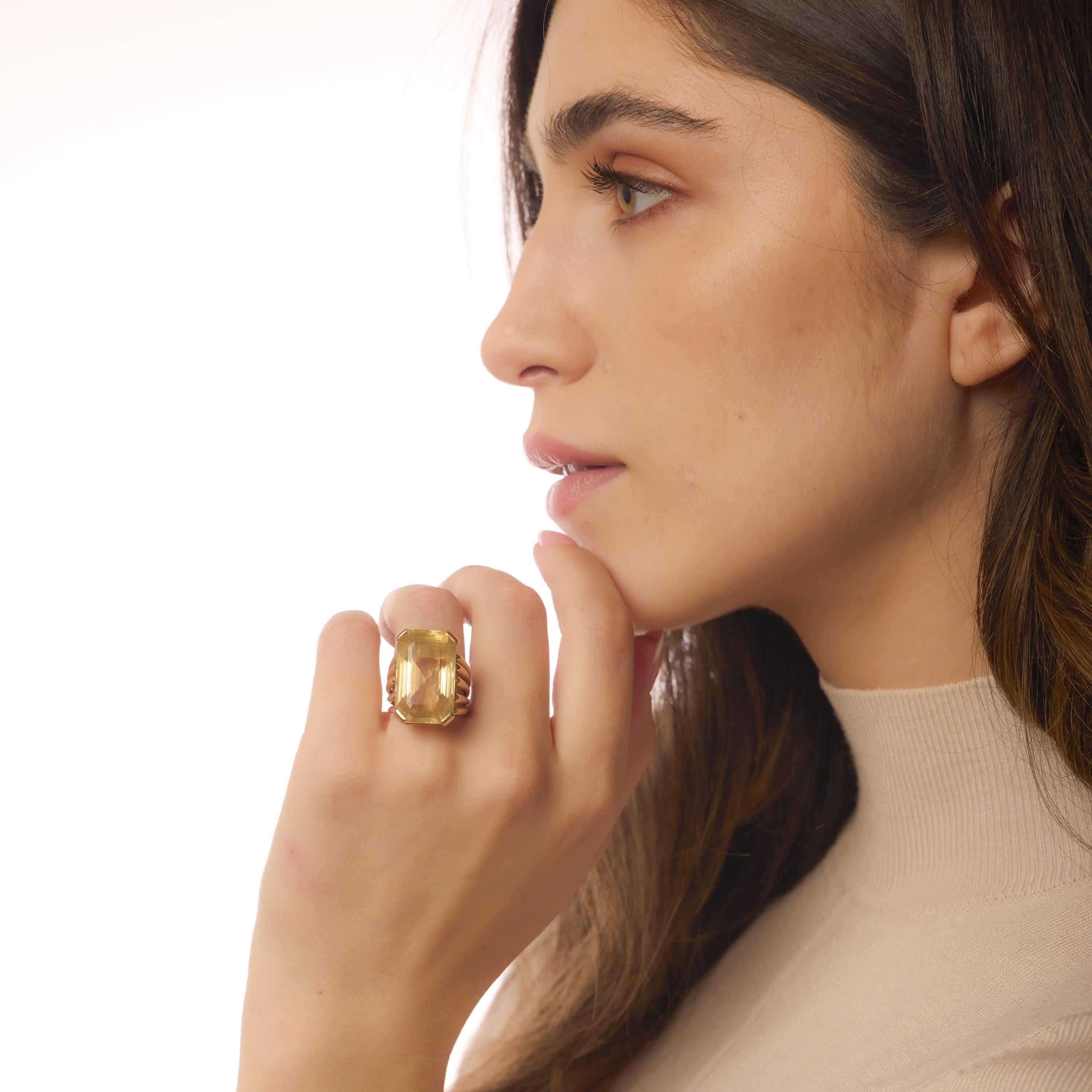 Questo audace anello d'epoca mette in mostra un sorprendente citrino da 34,40 carati taglio smeraldo in caldo oro giallo 18 carati, irradiando un'eleganza dorata e una raffinatezza senza tempo.