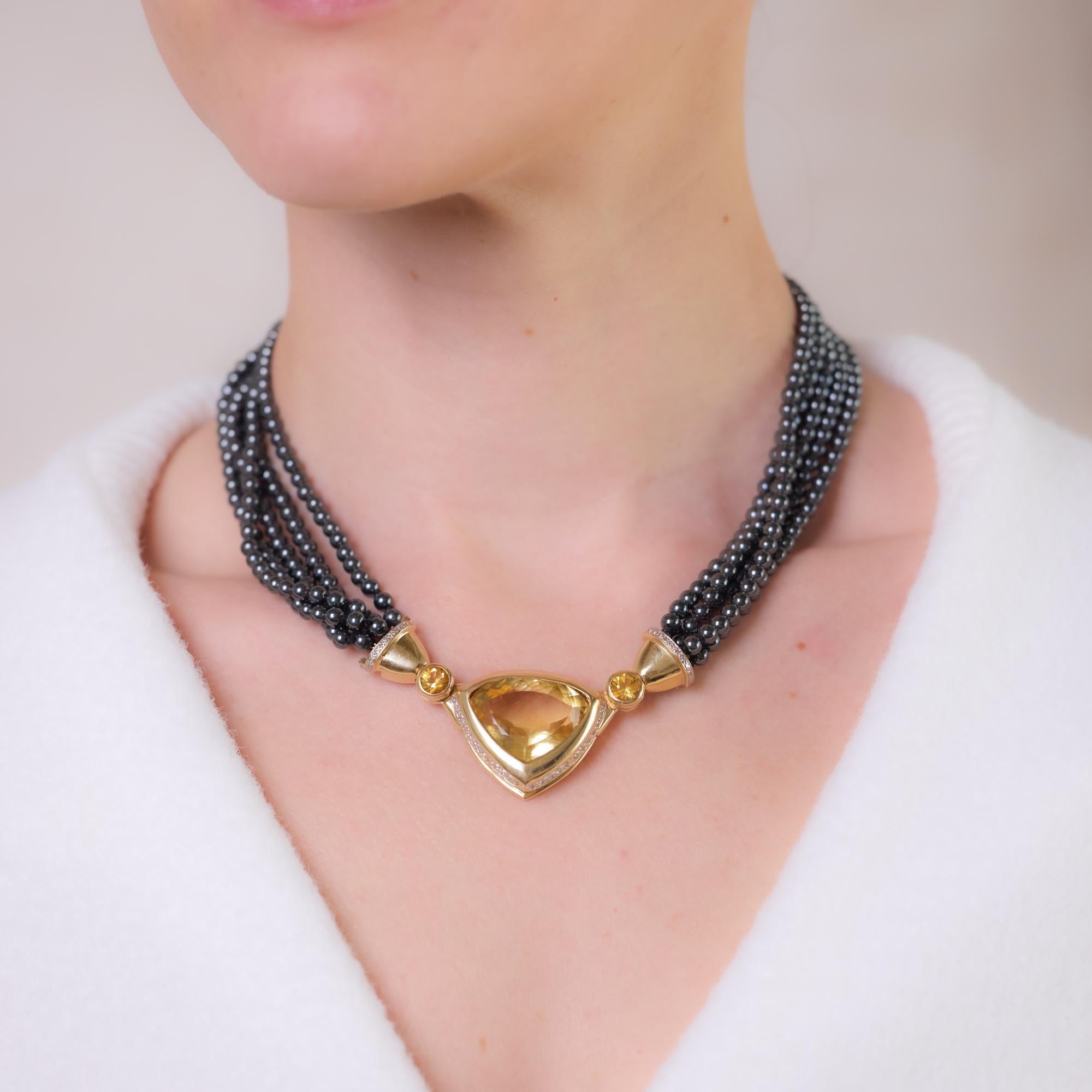 This vintage 14k yellow gold necklace features a striking 30-carat trillion-cut citrine centerpiece, accented by two round brilliant cut citrines totaling approximately 1.30 carats, 42 single cut diamonds totaling approximately 0.30 carats, H-I