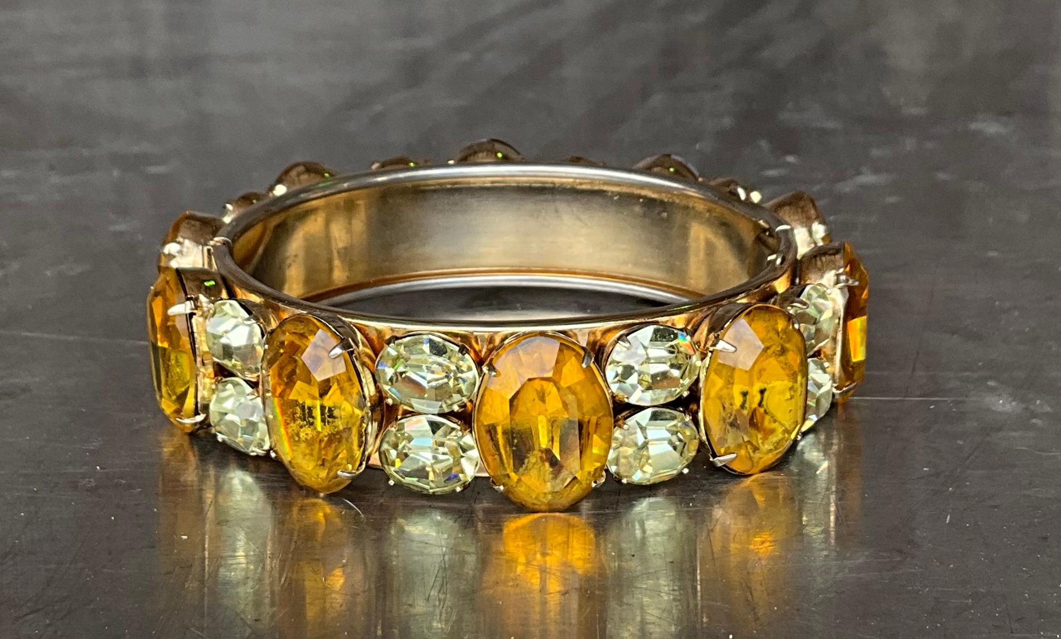 Questo braccialetto vintage con citrino e strass è un esempio di lusso d'epoca, realizzato con una meticolosa attenzione ai dettagli. Il braccialetto è realizzato in metallo color oro o argento, con una finitura classica e lucida che contrasta