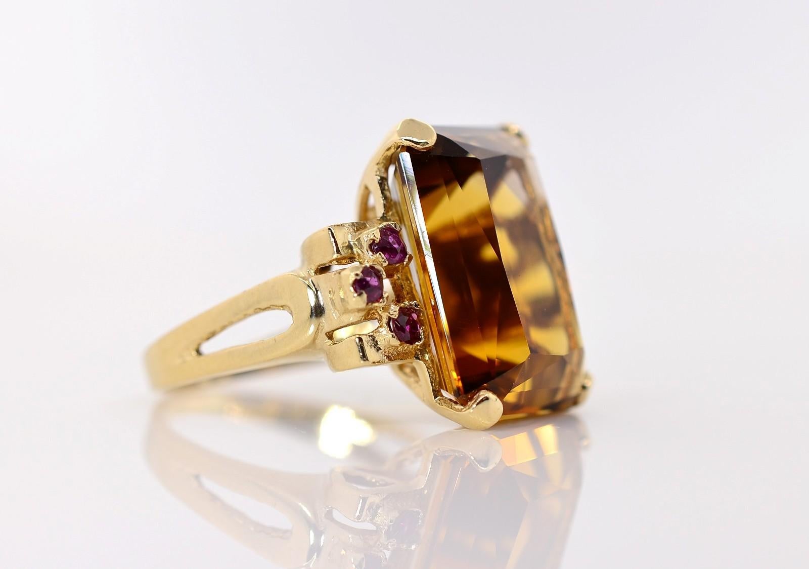 A sparkling Madeira Citrine quartz weighing 14.00 carat is the center piece of this lovely 1950's ring.  Three Burma Rubies flank each side of the Citrine in the 14KT yellow gold setting.  A split band adds understated ornamentation to this pretty