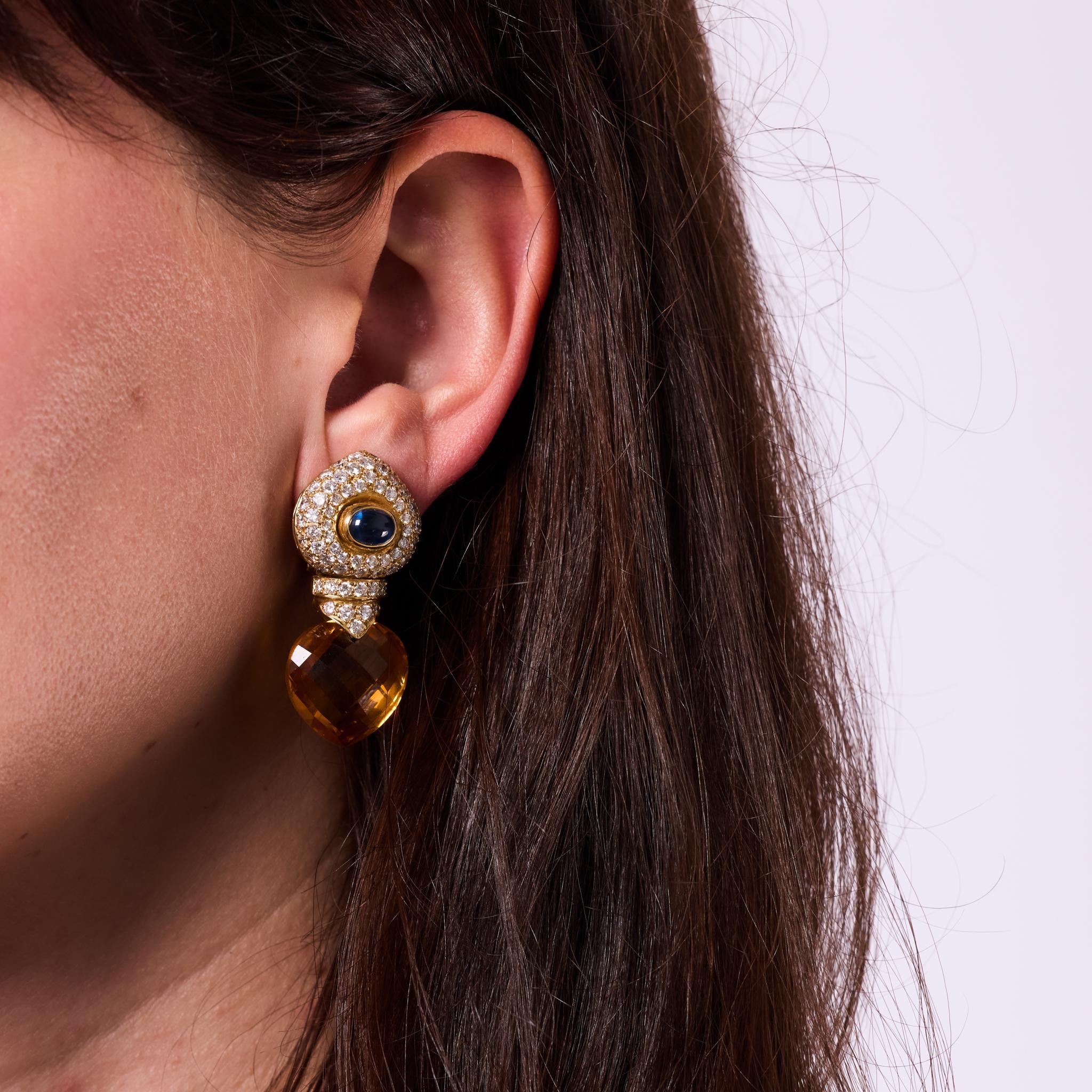 Fabricados en la década de 1980, estos pendientes vintage son una declaración de lujo con piedras preciosas de ricos colores y un diseño atrevido. Cada pendiente exhibe un citrino talla pera briolette de aproximadamente ¾ x ¾ pulgadas, suspendido