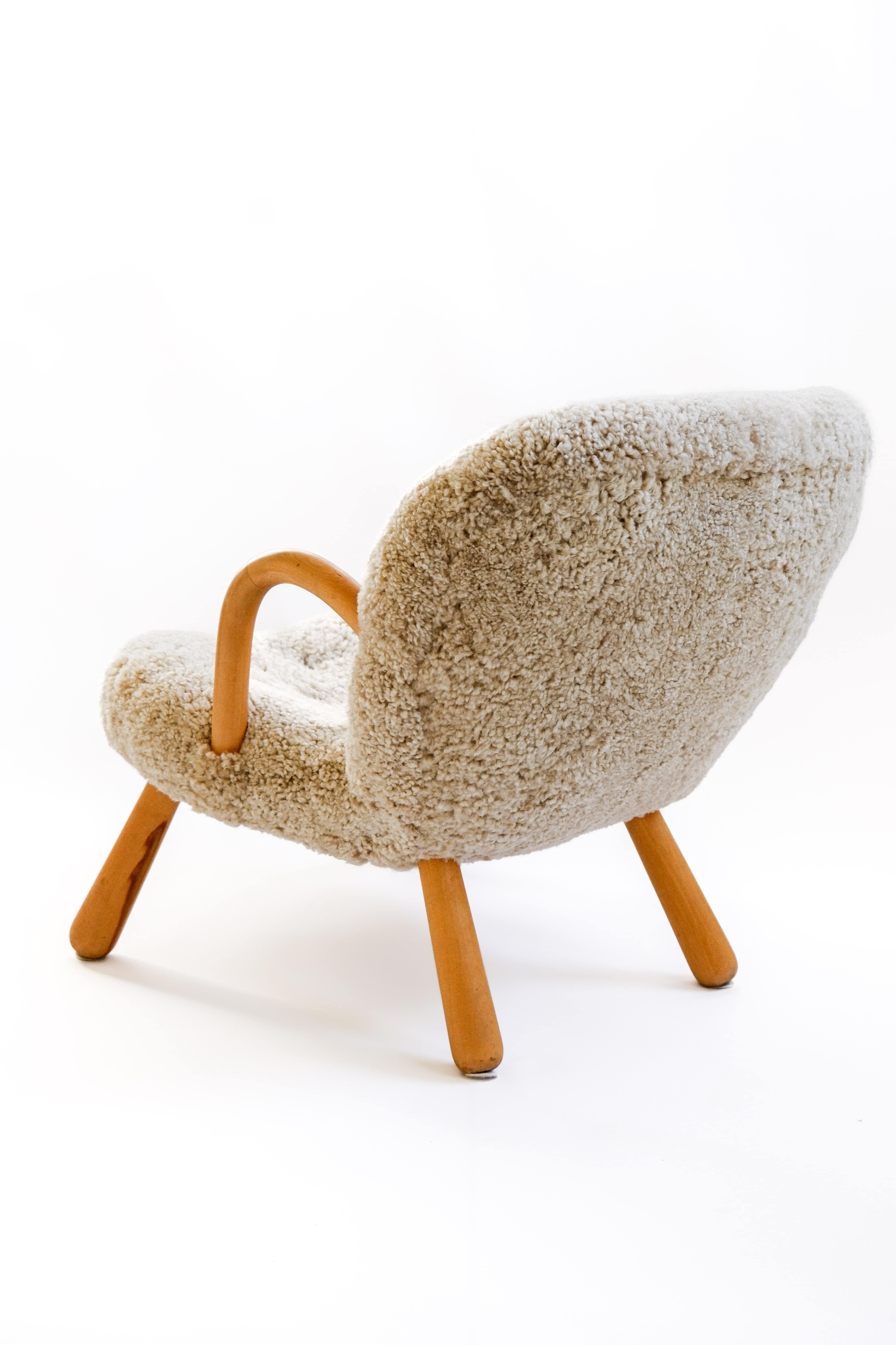Iconic Clam chair designed by Arnold Madsen for Madsen & Schubell in Denmark in 1944. This example is a vintage original armchair produced in the 40's in danemark. The chair has been reupholstered in premium Sheepskin from New Zeland. The arm chairs
