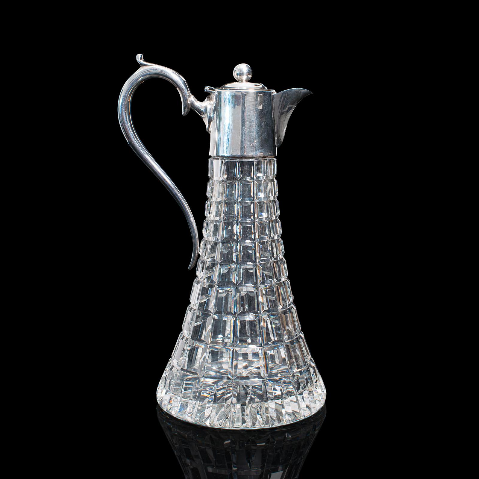 This is a vintage claret jug. An English, cut glass wine or spirit decanter, dating to the late 20th century, circa 1980.

Beautifully cut glass jug with bright appearance
Displays a desirable aged patina and in very good order
Quality square