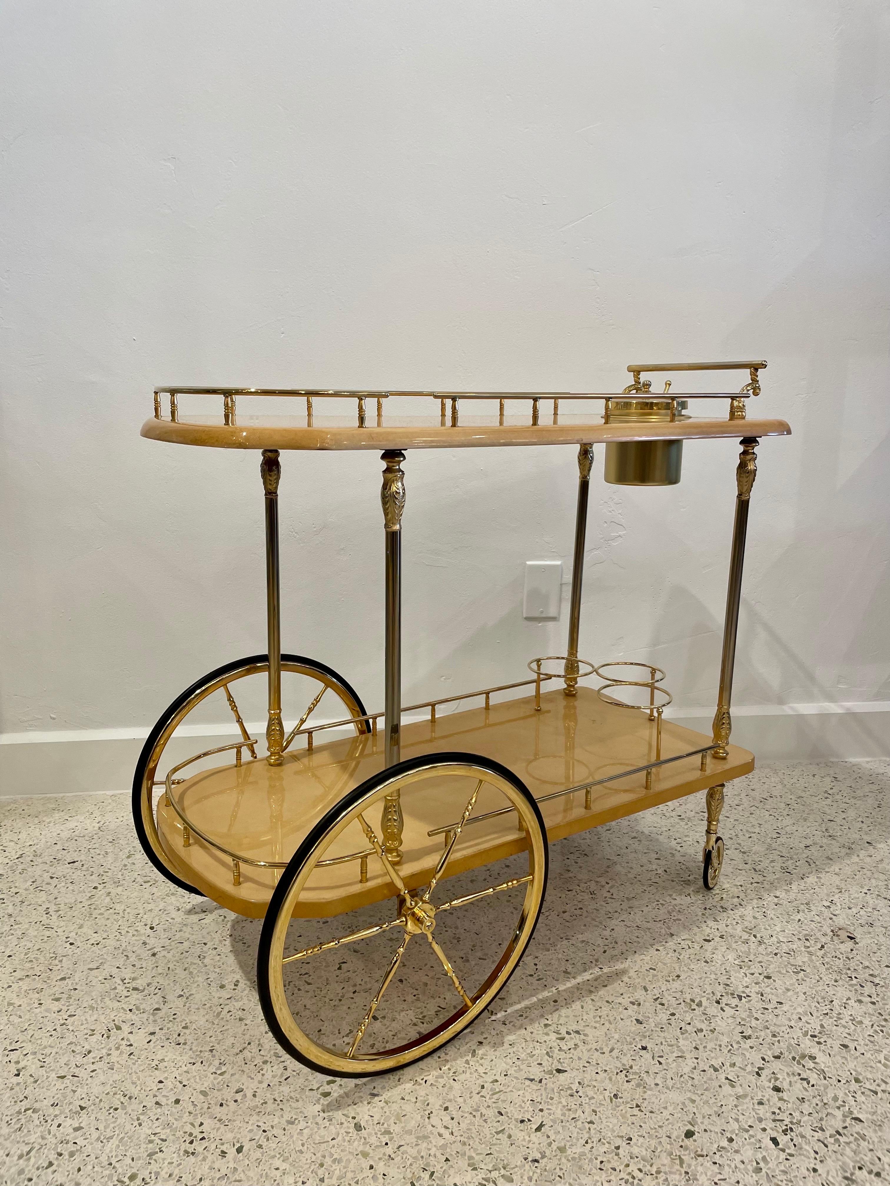 An original vintage Aldo Tura bar cart in classic parchment tone lacquered goatskin and gold plated metal. Very classic Italian mid-century modern look. Signed underneath.