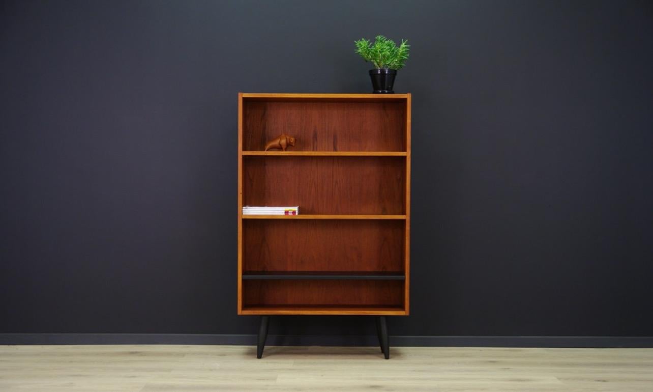 Classic 1960s-1970s bookcase with a minimalistic form, Danish design. Surface veneered with teak, adjustable shelves. Bottom shelf painted in black. Preserved in good condition (small dings and scratches), directly for use.

Dimensions: height