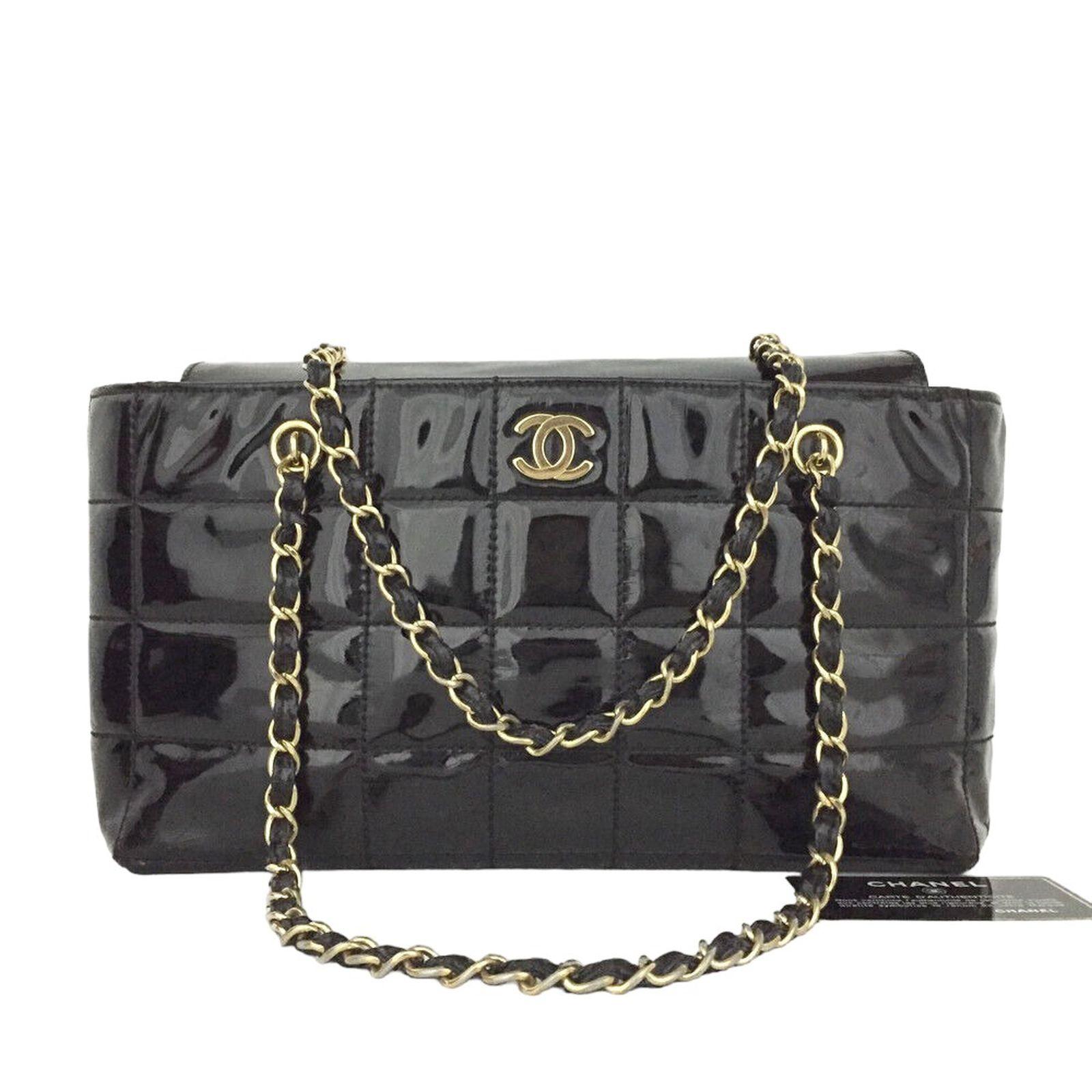 Classic Chanel Black Enamel Shoulder Bag. Leather Chicklet Design. Vintage Chanel with gold color accents. CC in the front of the bag. Leather and gold straps. The interior of the bag is leather and has separating compartments. The interior has a