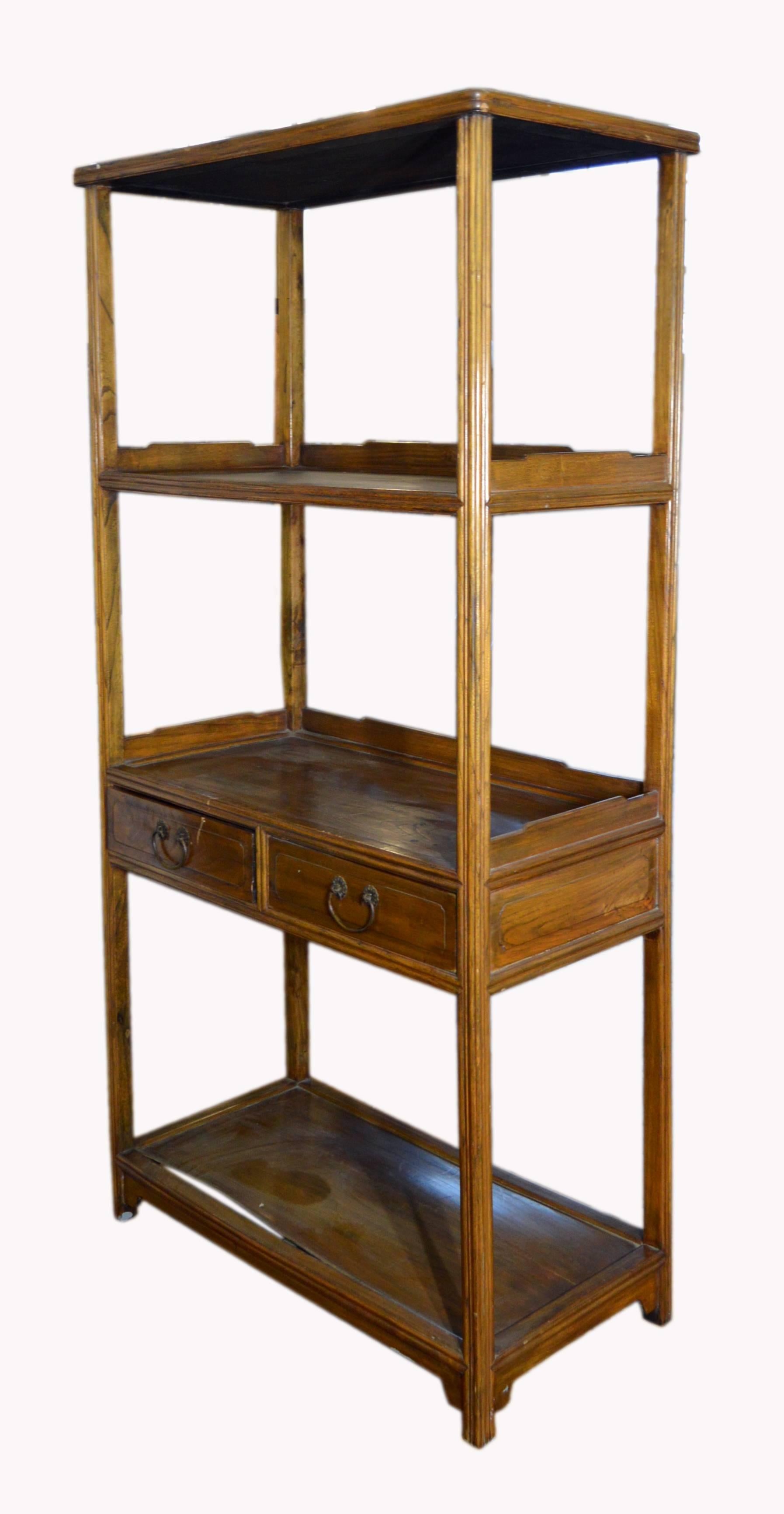 A Chinese early 20th century classic design bookcase with four shelves and two drawers. Crafted during the early 20th century, this wooden Chinese bookcase displays a classic design with two drawers. This elegant tall linear bookshelf features four