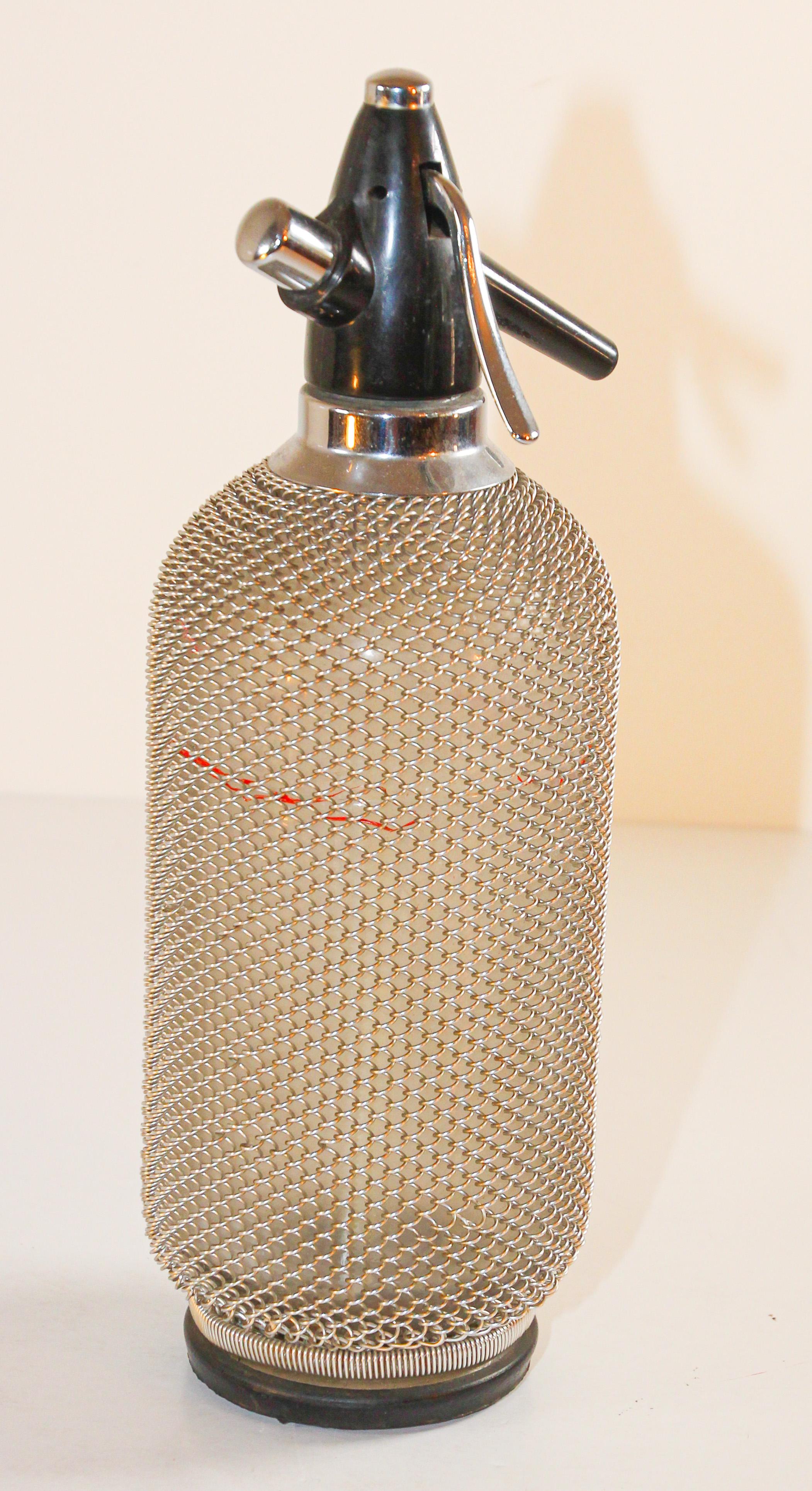This is a fantastic vintage seltzer bottle with a metal wire mesh casing around the glass from the 1970.
Enjoy the fresh and healthy fizz of sparkling water, carbonated juice drinks, wine spritzers, and handcrafted cocktails. 
Vintage barware