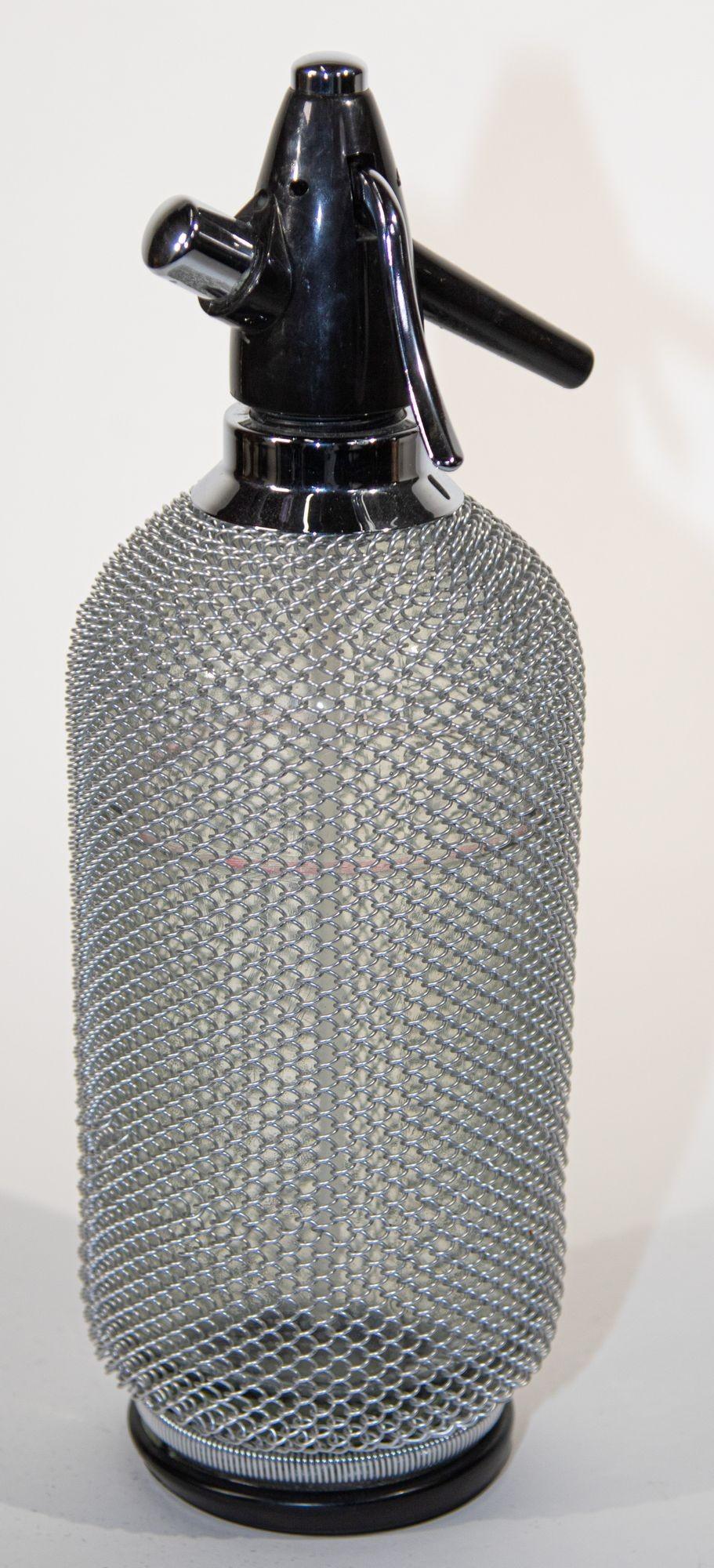 Vintage Classic Siphon Soda Seltzer Glass Bottle with Wire Mesh.
Il s'agit d'une fantastique bouteille d'eau de Seltz vintage avec une enveloppe en treillis métallique autour du verre.
Bouteille d'eau de Seltz vintage fabriquée en