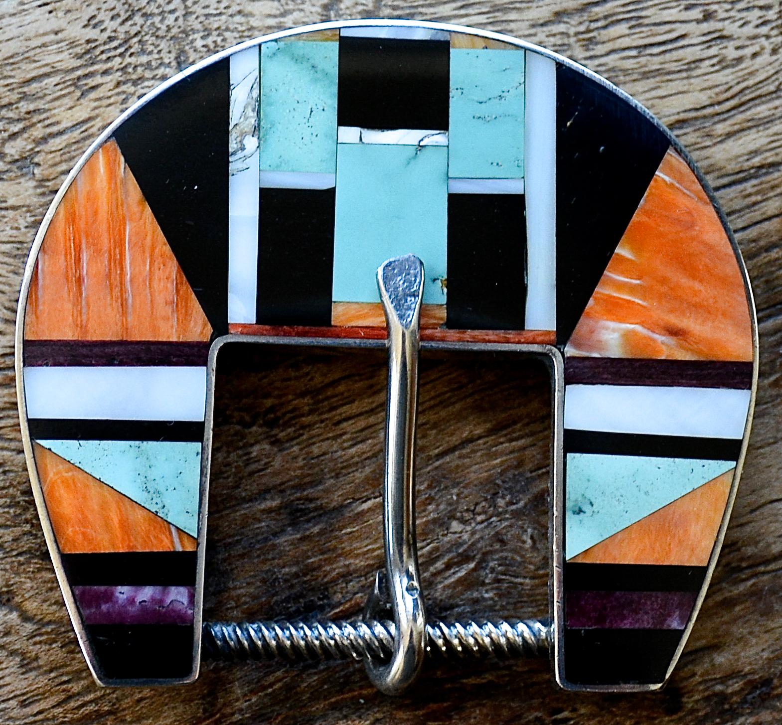 Un esempio straordinario di set di fibbie da ranger d'epoca Zuni intarsiate e in argento sterling, circa anni '70. 

Questo classico set da ranger di Zuni è composto da turchese, giaietto, madreperla, sugilite e conchiglia di ostrica intarsiata in