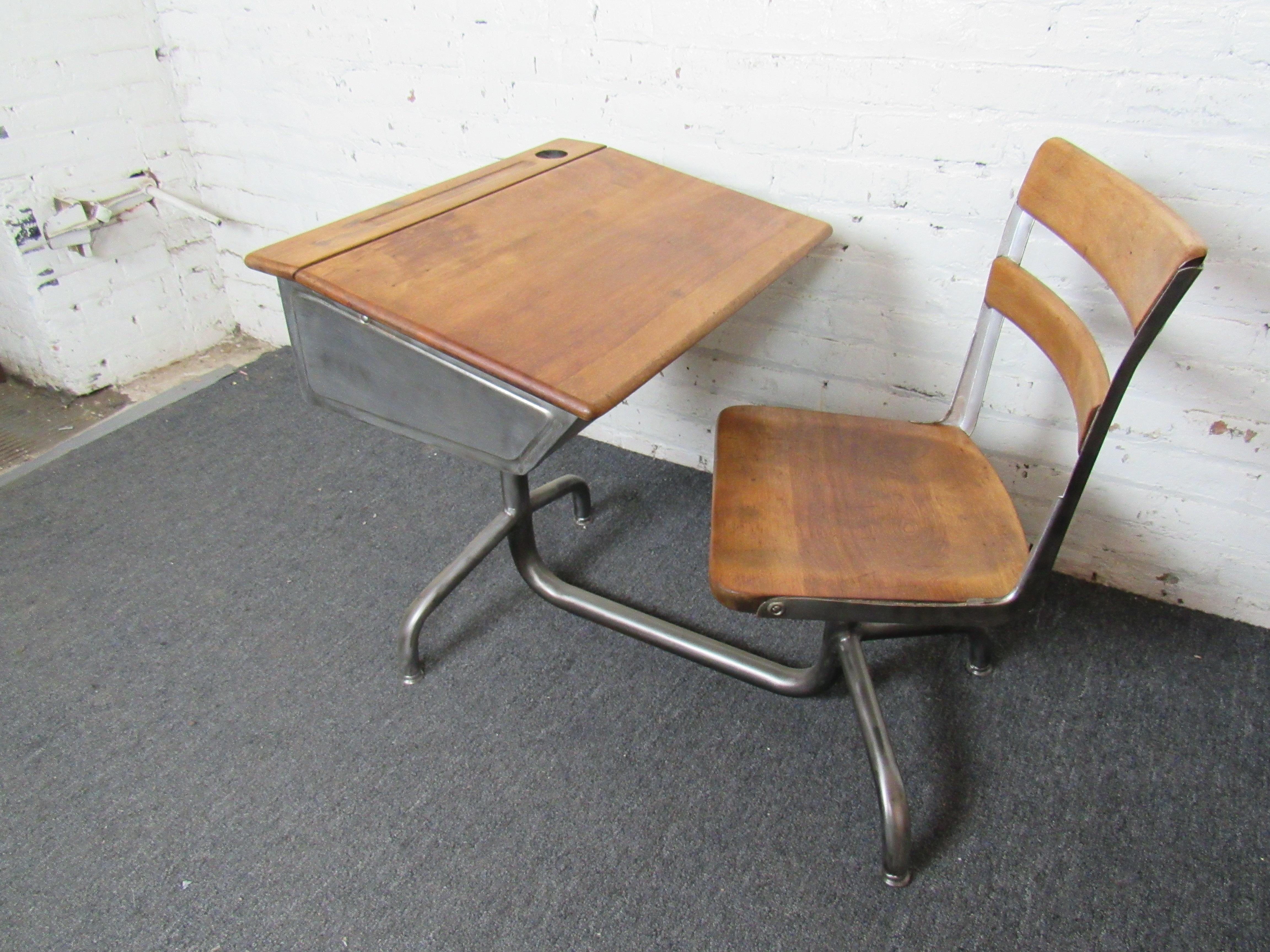 Vintage classroom desk and chair that has been beautifully refinished. The chair rests on a swiveling base, and the desktop raises to reveal a large storage compartment with an adjustable setting of a flat or slanted writing surface. Please confirm