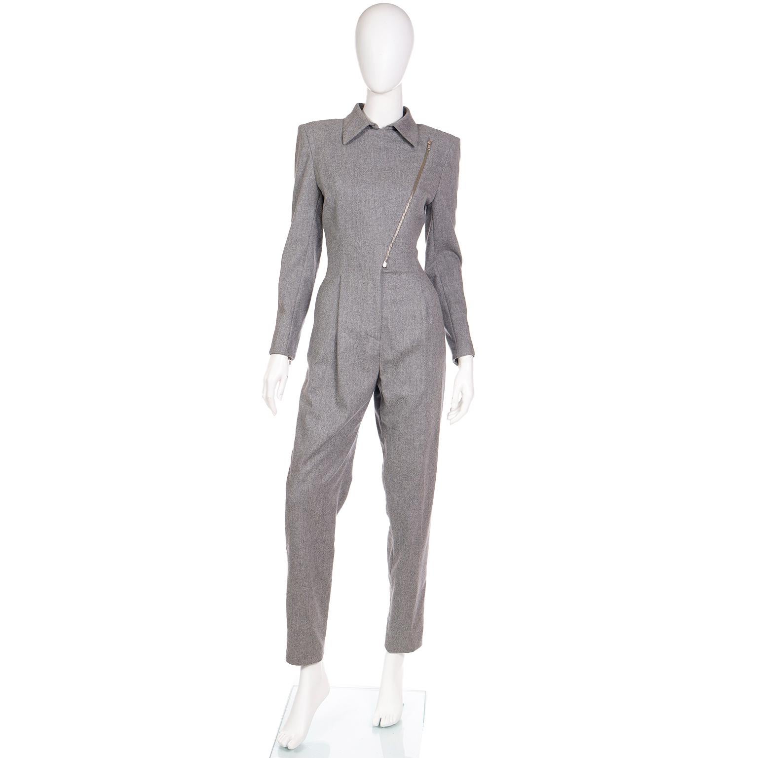 This is a spectacular vintage Claude Montana heather grey wool jumpsuit with many of Montana's signature details. The asymmetrical zip front bodice was a common design in Claude Montana's pieces and the high neckline and fitted waist create a