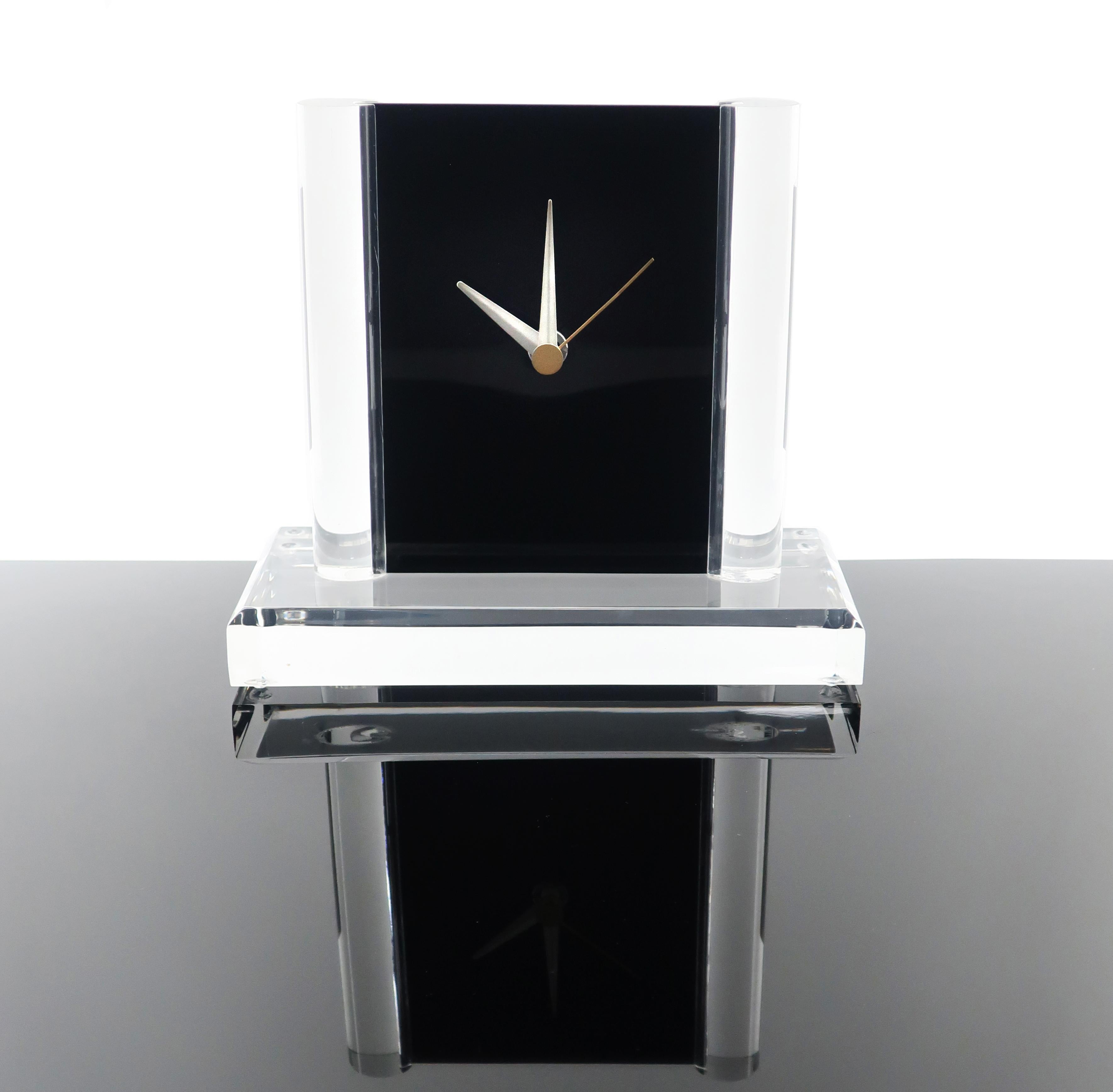 Set on a faceted clear lucite base and round lucite columns, the movement for this charming clock is housed inside two pieces of black acrylic that fit together and slide down into the base. Clean lines, simple elegance, and perfect modern