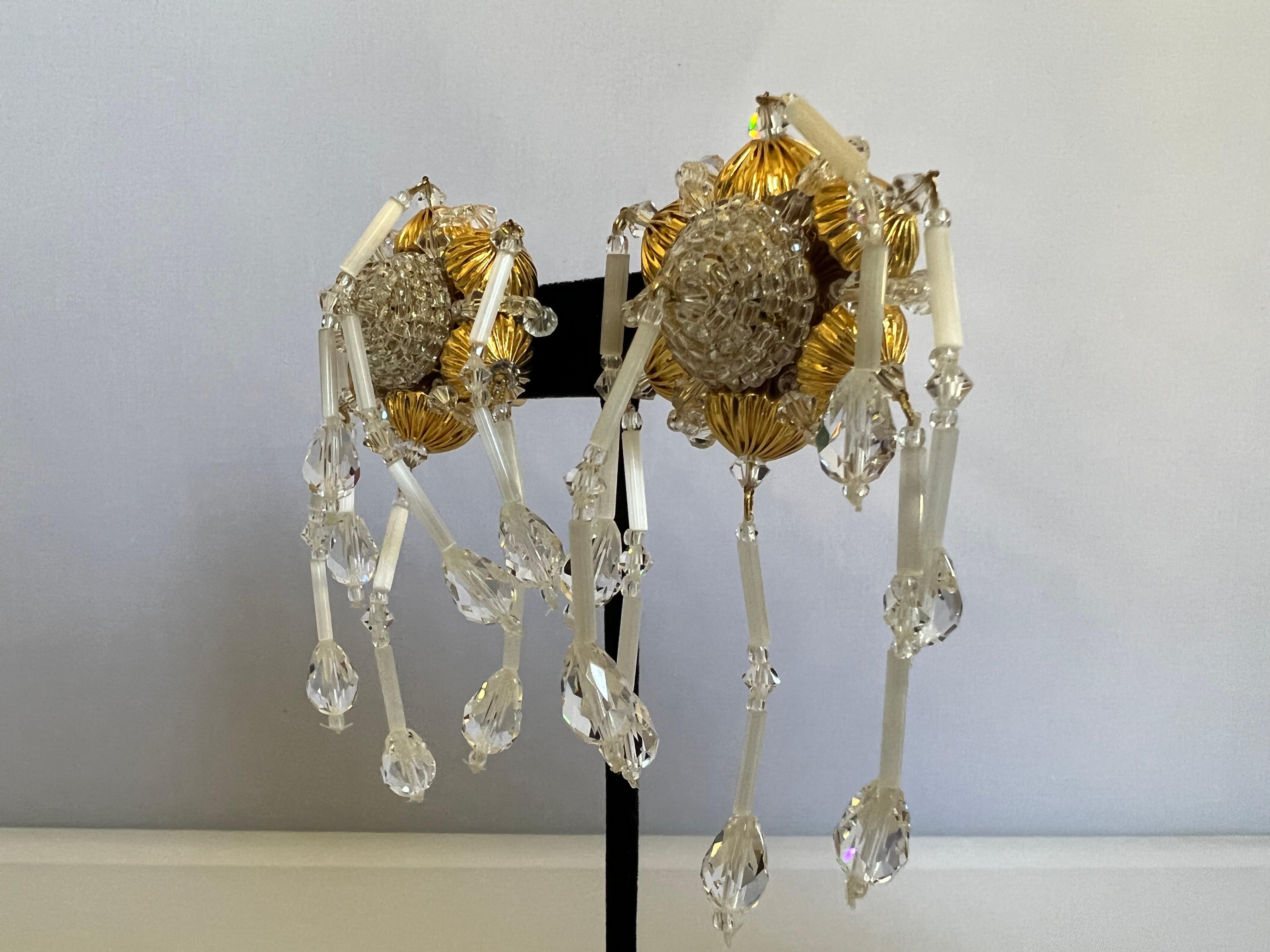 One-of-a-kind vintage firework clip-on earrings by Robert F. Clark for William de Lillo, comprised of round textured gilt beads, and faceted clear glass beads all intricately hand-beaded to form a cascading firework. Unique pair made in France circa