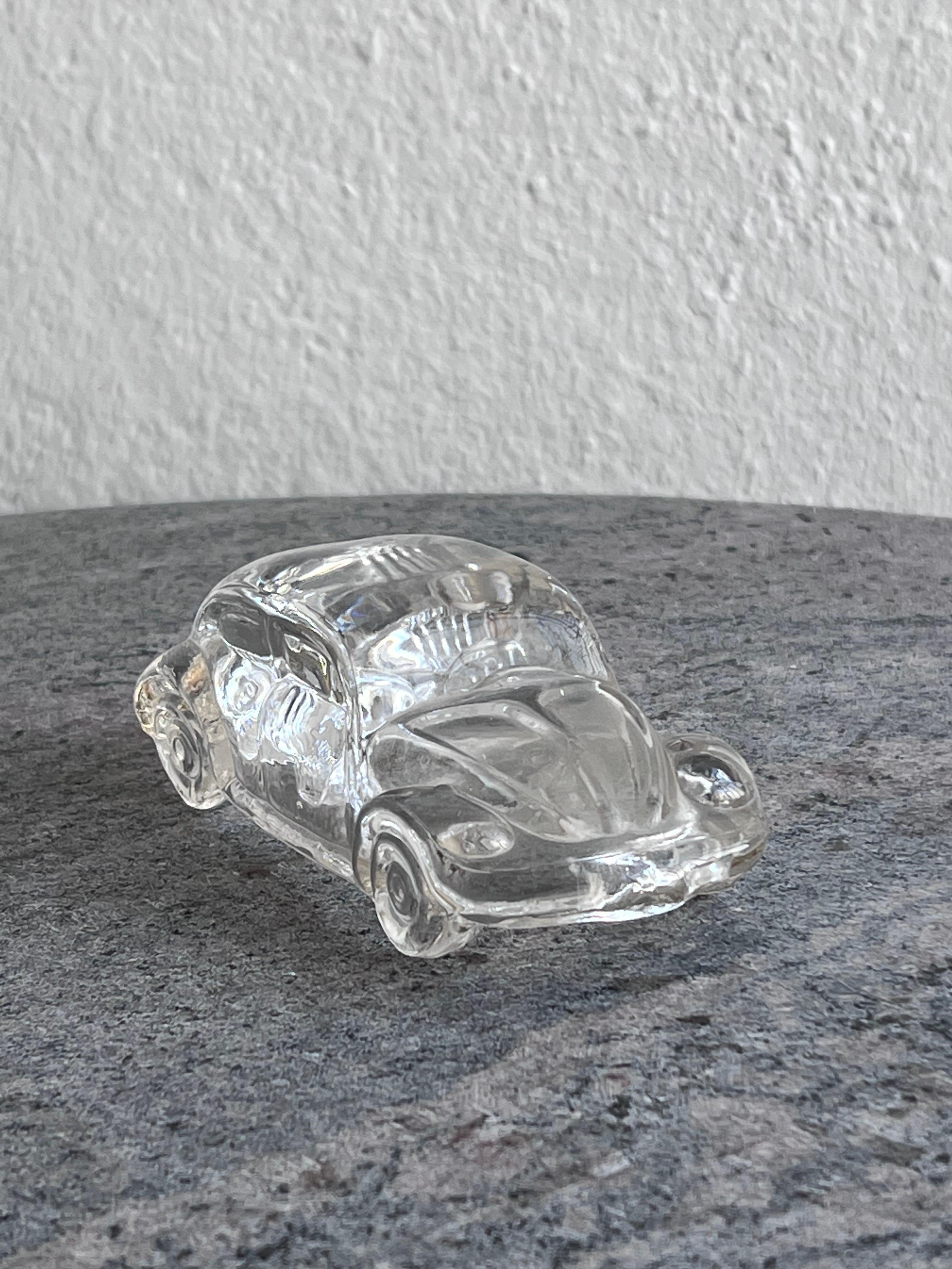 Little but realistic miniature model of a classic Volkswagen Beetle - most likely a version from the late 1970s/early 1980s. It is made in pressed clear glass, and is rich in details, to the point it even shows the iconic ribbed bonnet. The