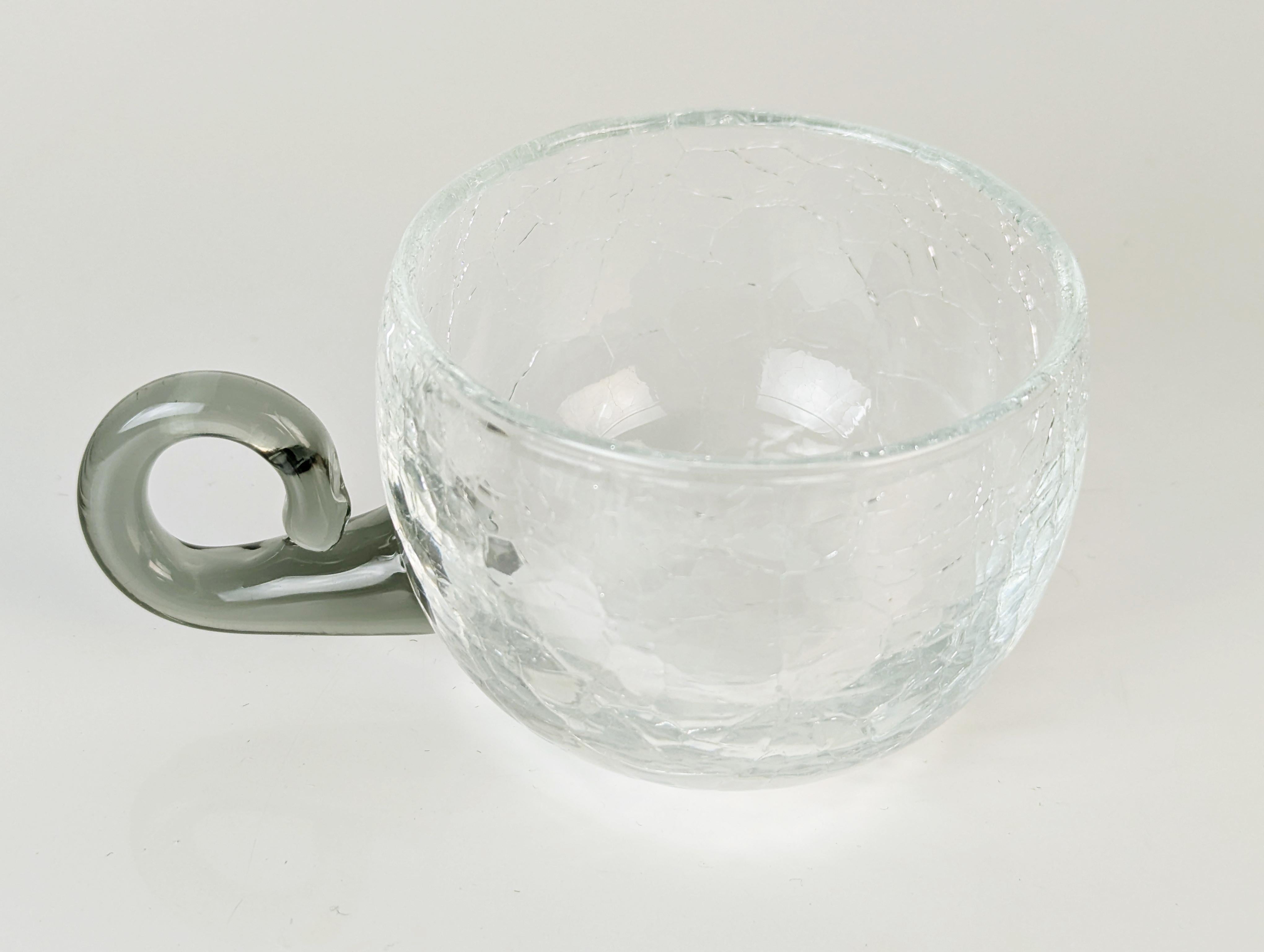 Juego de ponche de cristal artesanal vintage compuesto por un bol grande y 9 tazas.
Las piezas de cristal transparente son muy gruesas y tienen un tratamiento superficial craquelado. Las asas son de cristal gris transparente hecho a mano.
Ideal como