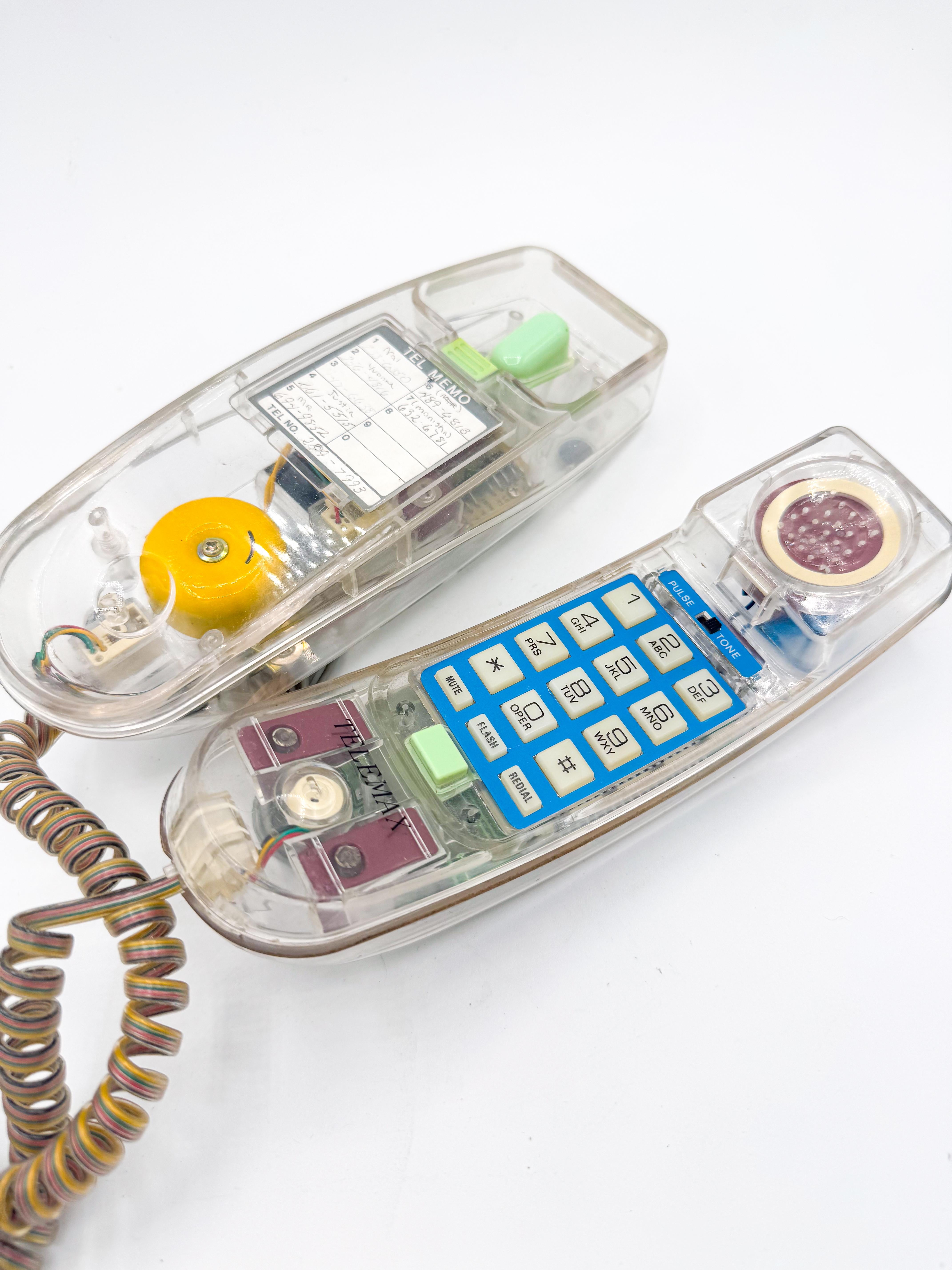 A striking postmodern design object from the 1990s, this transparent push-button landline telephone is a nostalgic celebration of Y2K-era aesthetics. The clear plastic casing reveals the internal wiring and circuitry in vivid detail, transforming a