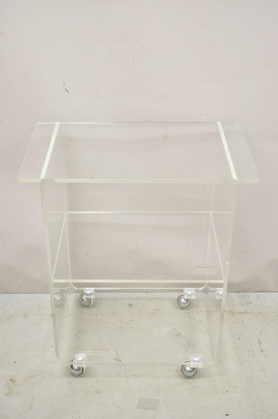 Vintage Clear Lucite Acrylic Mid Century Modern Rolling Bar Cart Side Table. Middle and lower shelf, rolling casters, clean Modernist lines. Circa Late 20th Century. Measurements: 32