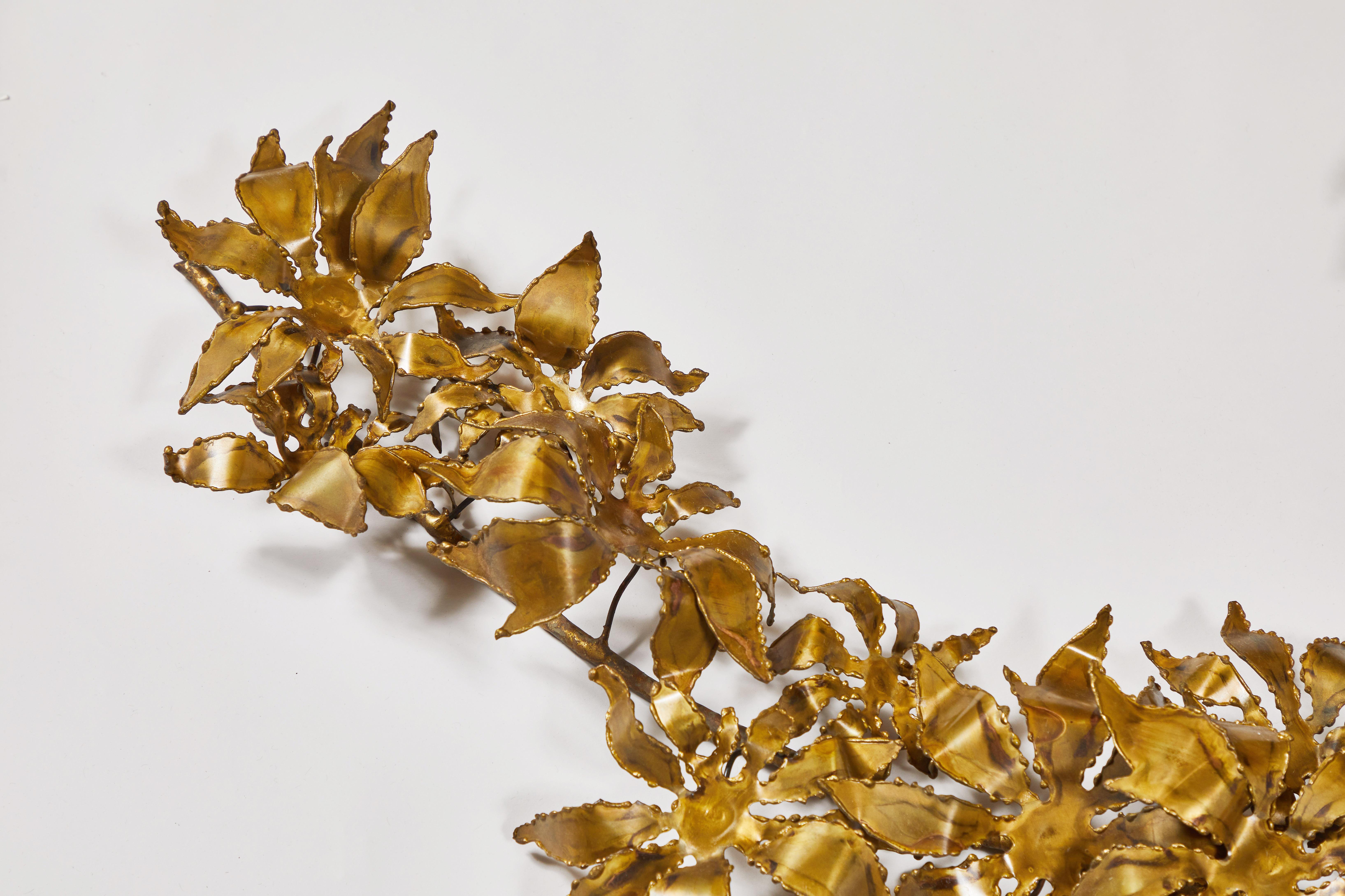 This vintage abstract leafy metal wall sculpture with spiky flowers is signed in ink on one of the petals by California artist Cliff Widdowson and dated 1973. In brass, this wall-mounted brutalist artwork has several hangers on its back for