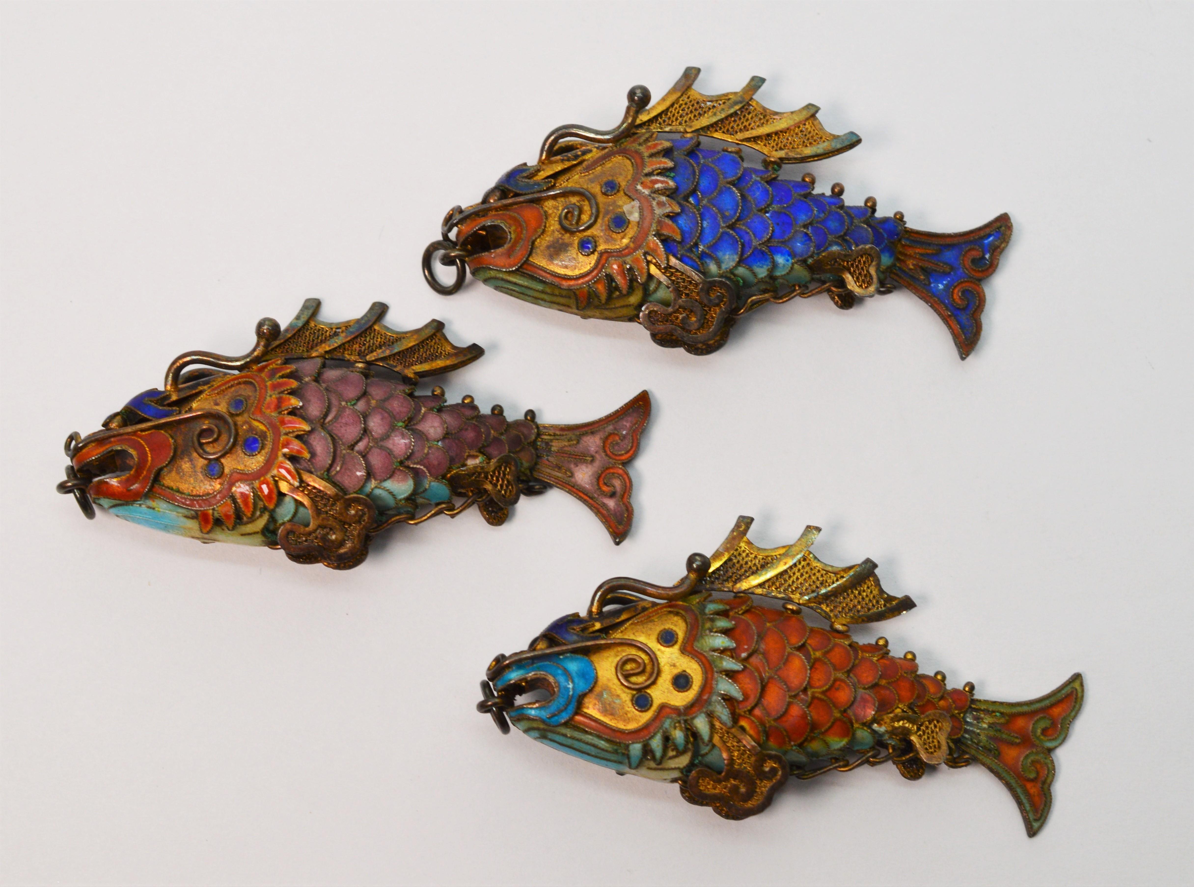 An artful and fun school of three imaginative Chinese Cloisonne Enamel Koi Fish Pendant Charms. Made of gilt silver with hand painted enamel, each Koi is unique in color and design with articulated fish tails that move. Circa 1920 - 1930 as a
