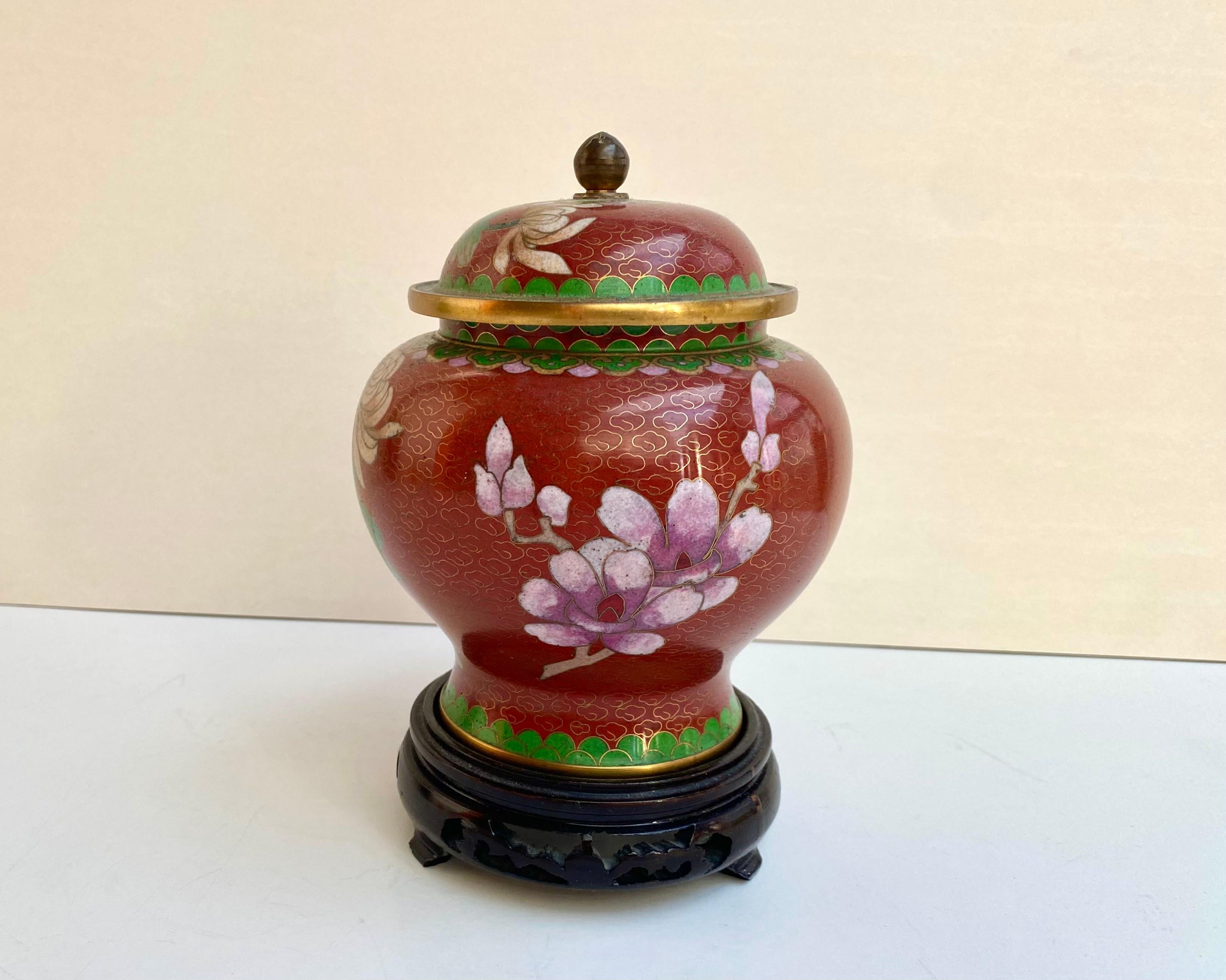 Verschnörkelte Cloisonné-Deckelvase auf Holzständer mit rotem Hintergrund! China, 1970er Jahre.

Dieses bezaubernde Gefäß hat ein florales Design mit einem Vogel.

Vintage Ingwer Glas In schöner Form, wie auf den Fotos gezeigt.

Über die Geschichte