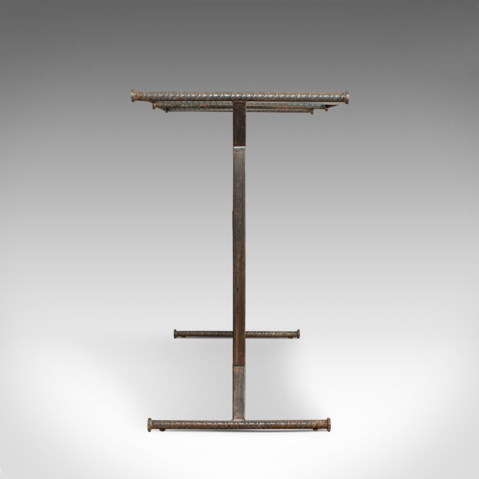 This is a vintage clothes hanging rail. An English, steel and oak retail display stand in industrial taste, dating to the 20th century.

Steel and select cuts of oak in strong industrial taste
Dark hues throughout and displaying a desirable aged