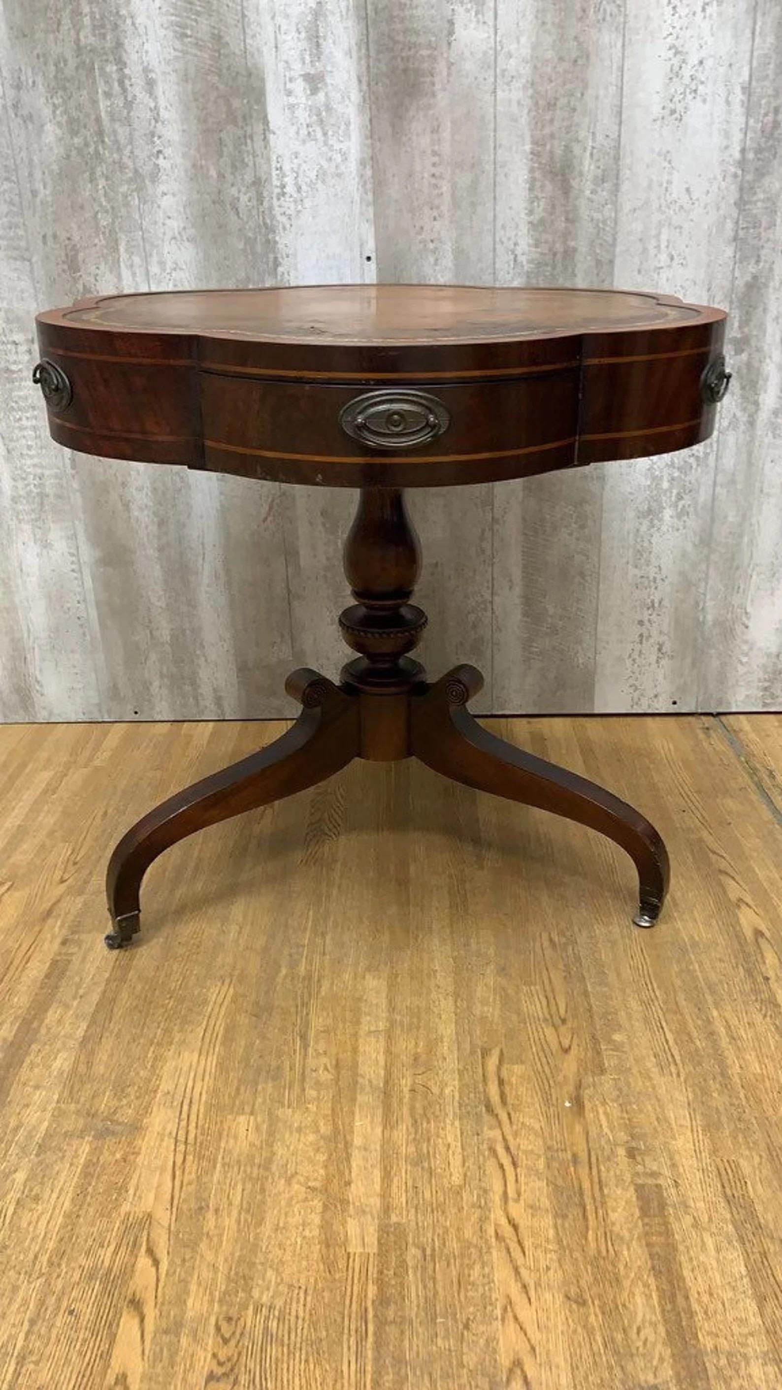 Tavolino a tamburo in mogano a bande di trifoglio d'epoca

Il tavolino a tamburo in mogano a fasce Clover Vintage è un pezzo straordinario che combina eleganza e funzionalità. Caratterizzato da un piano in pelle di ottima fattura, questo tavolo è