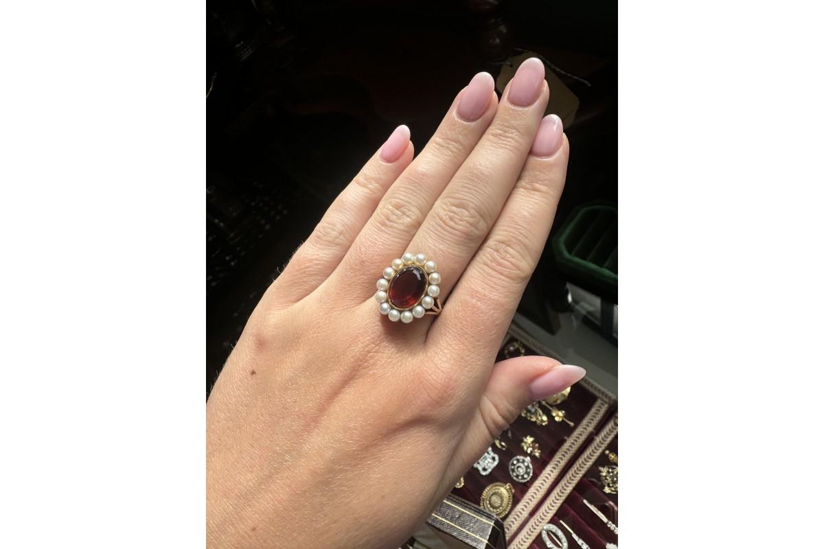 Cluster ring decorated with an oval orange citrine about 3,2ct surrounded by numerous cultured pearls.

Vintage ring set in 14-karat gold (0.585 fineness).

Width: 15 mm.

Size: 14 (54) - size adjustment possible.

Very good condition, no