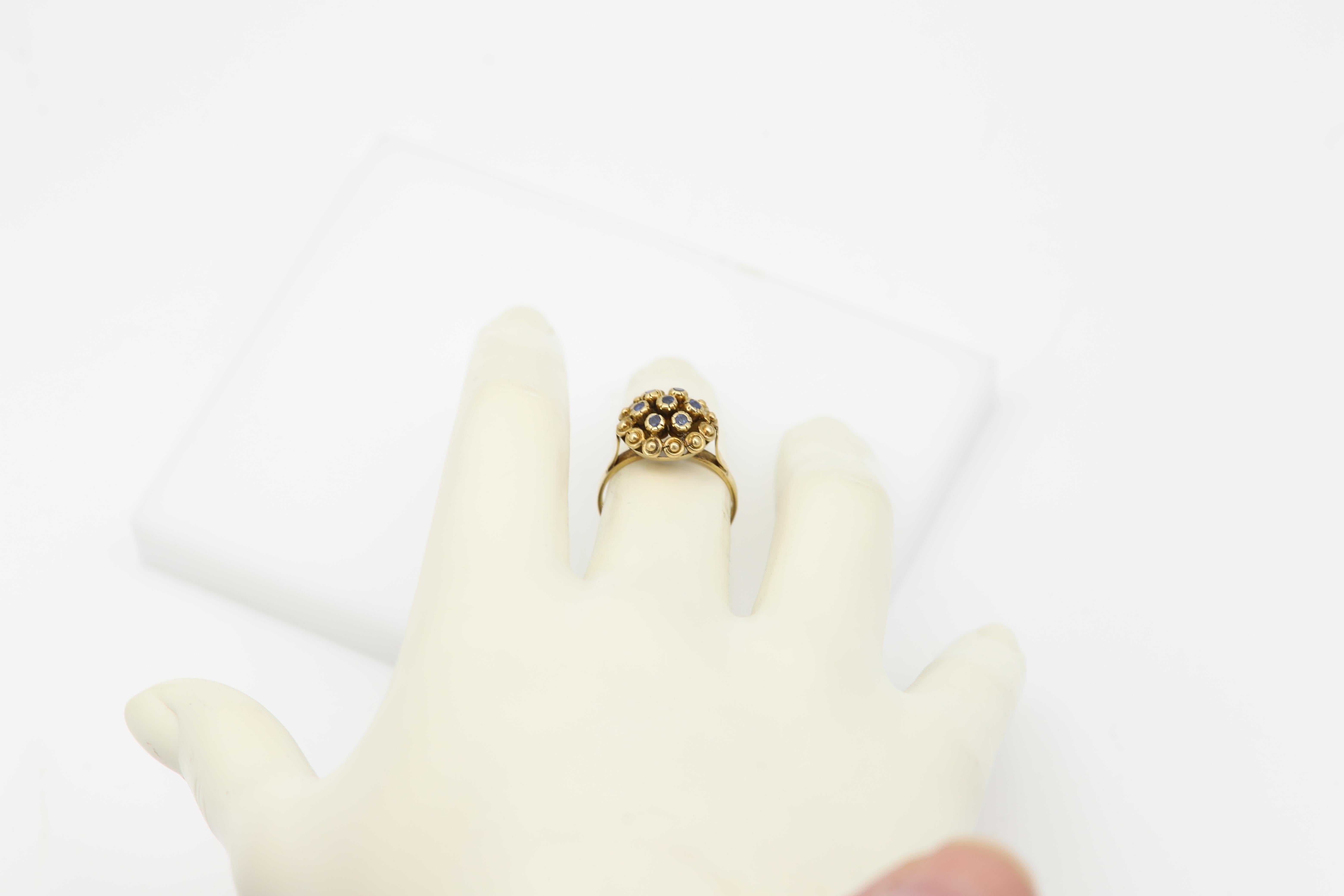 Vintage Sapphire Ring circa 1950's
Flower Dome Design Cluster
dome size approx  13 x 13 mm
Stones are small round natural blue sapphire Gemstone 
Finger size 6
18k Yellow Gold approx 3.5 grams
Pre-Owned in excellent condition
(#bjn4500_1938091)