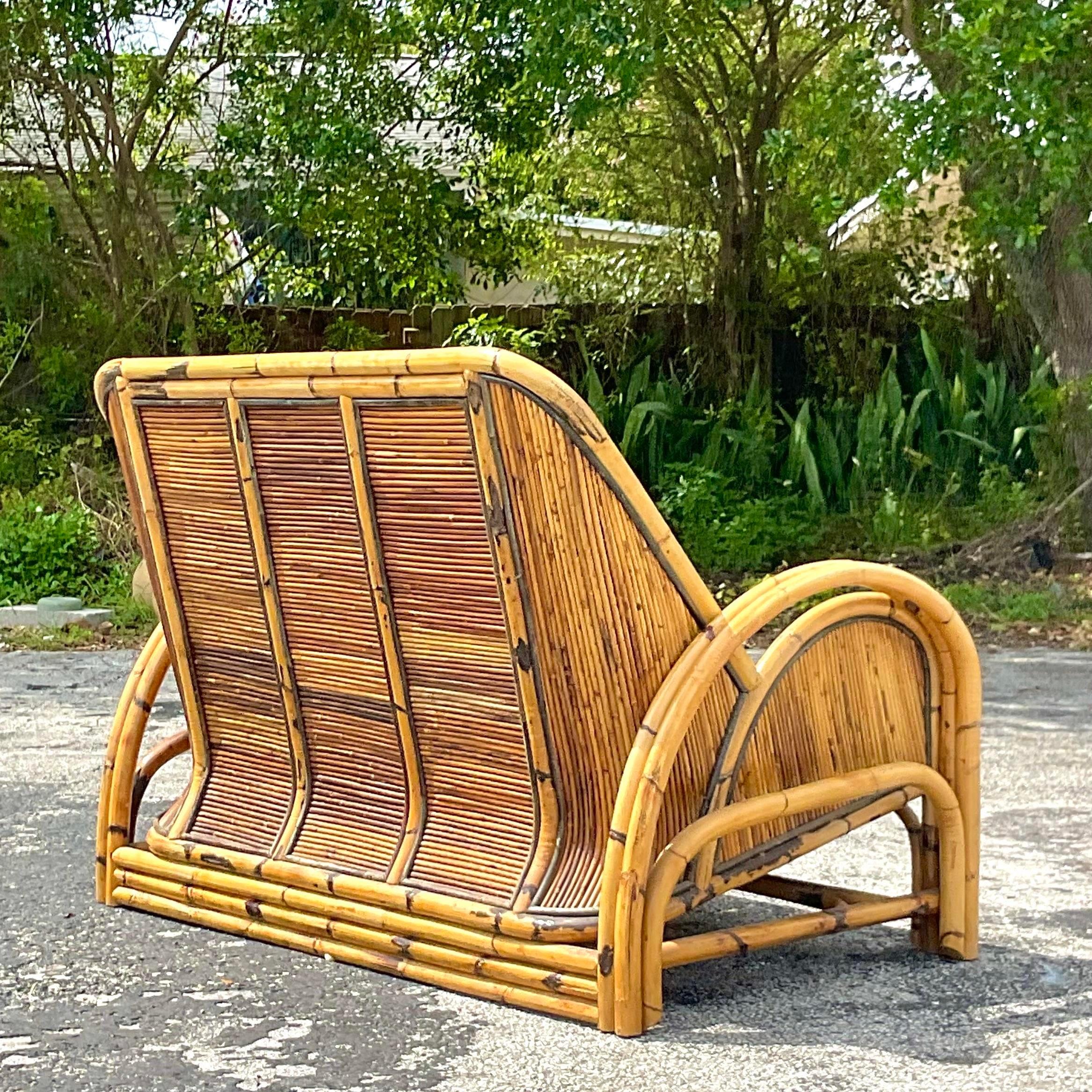 A striking vintage Coastal loveseat. A chic 1950s design made in a tortoise shell pencil reed. Coordinating chair also available on my page. See pics. Acquired from a Palm Beach estate.