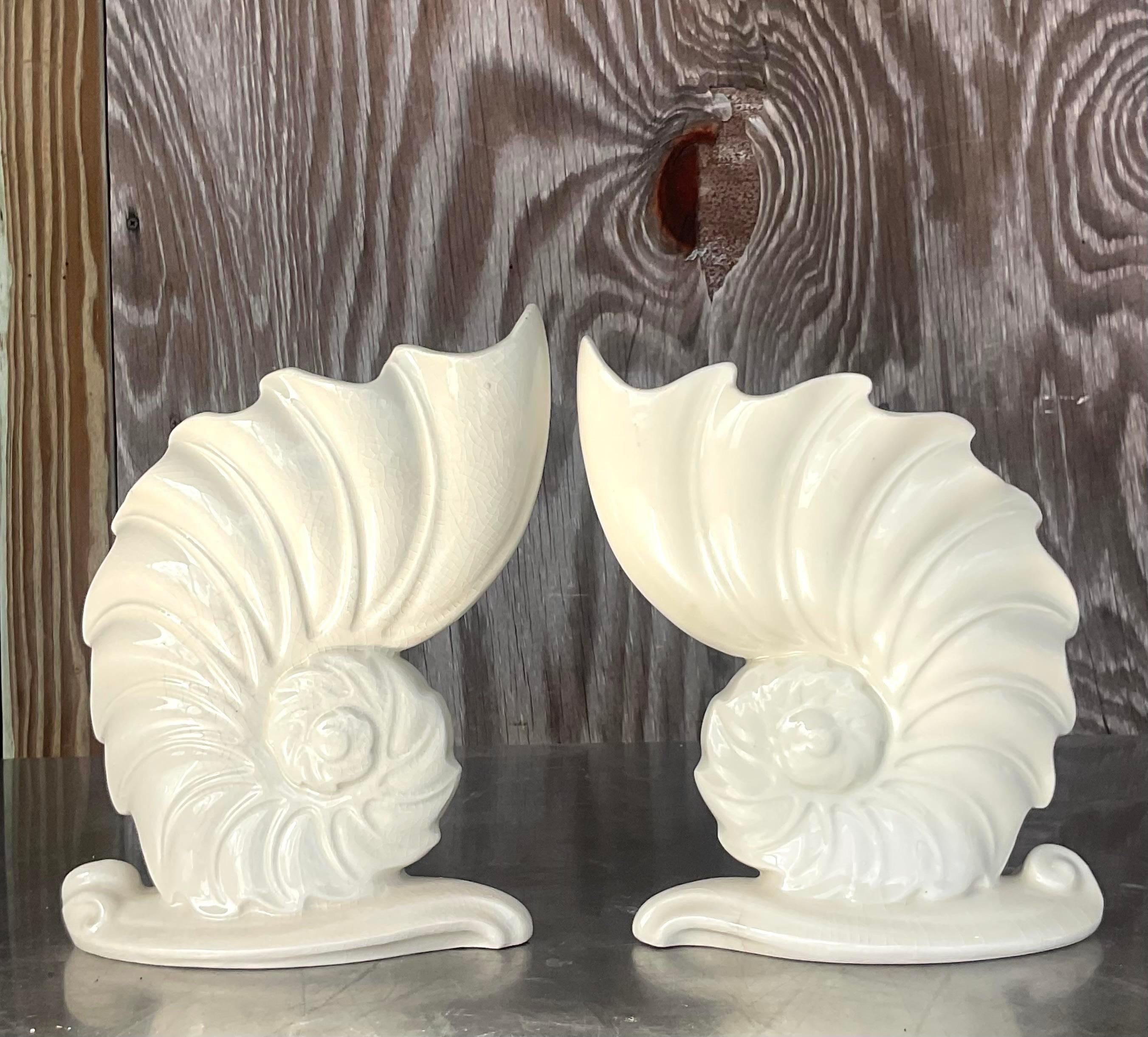 A fabulous pair of vintage Coastal vases. A chic abstract design of a Nautilus shell. A cool off white glazed ceramic finish. Acquired from a Palm Beach estate. 