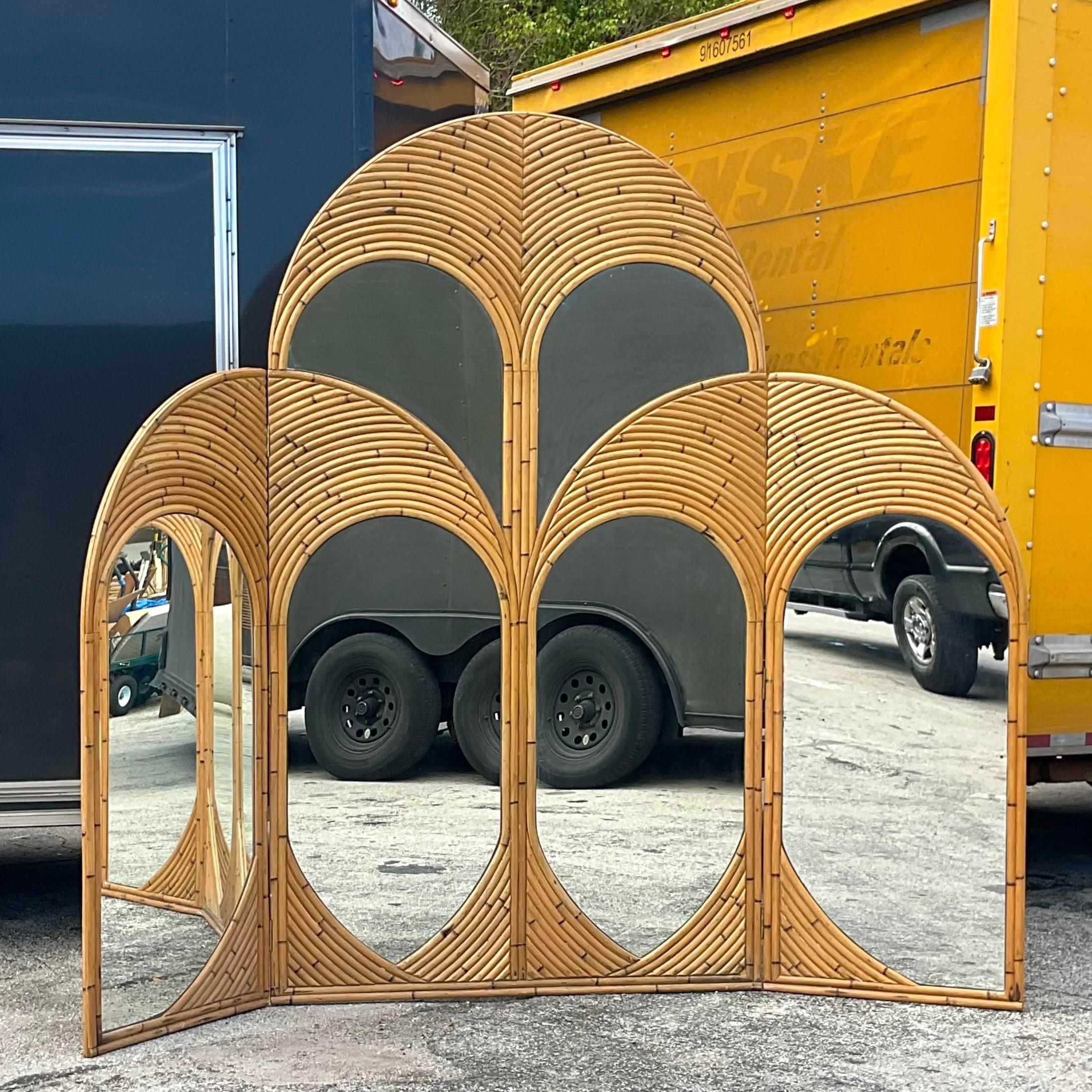 An exceptional vintage Coastal monumental screen. A chic arched bent rattan with inset mirrored panels. Perfect as a screen or also would be an amazing headboard. You decide. Acquired from a Palm Beach estate.