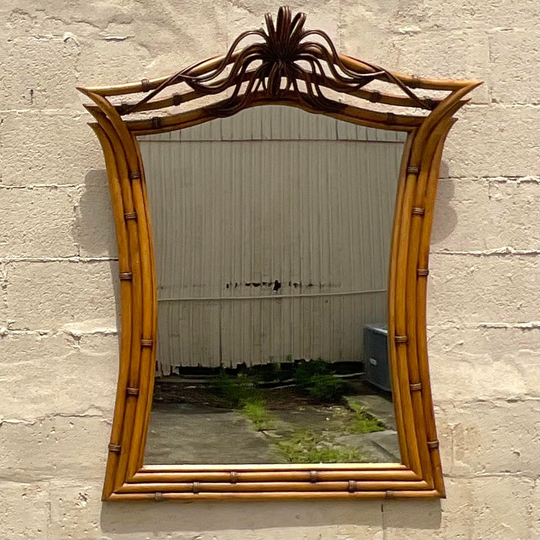 A fantastic vintage Coastal wall mirror. A chic tri band ring of bamboo with a fabulous rattan flourish at the crown. Acquired from a Palm Beach estate. 