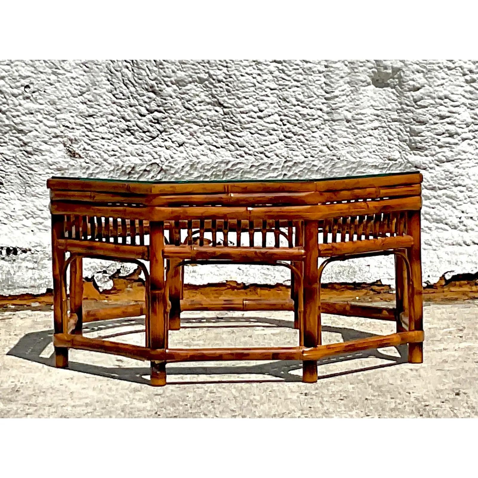 A fantastic vintage Coastal coffee table. A beautiful bamboo octagon shape with beautiful fretwork design. Glass top. Acquired from a Palm Beach estate.