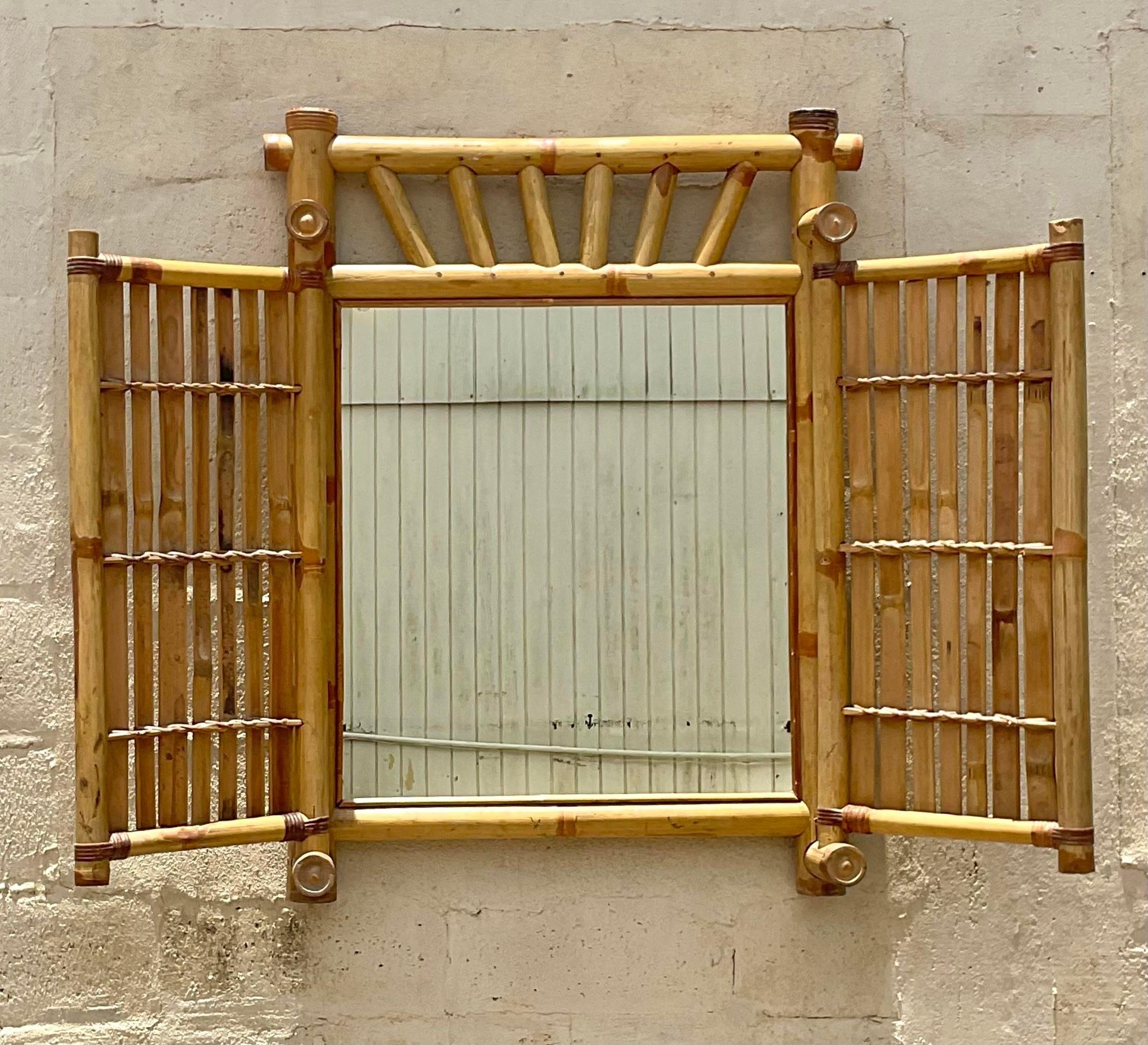 A fabulous vintage Costal wall mirror. A chic thick bamboo construction with a double door design. Acquired from a Palm Beach estate.

Doors open width 57 inches 