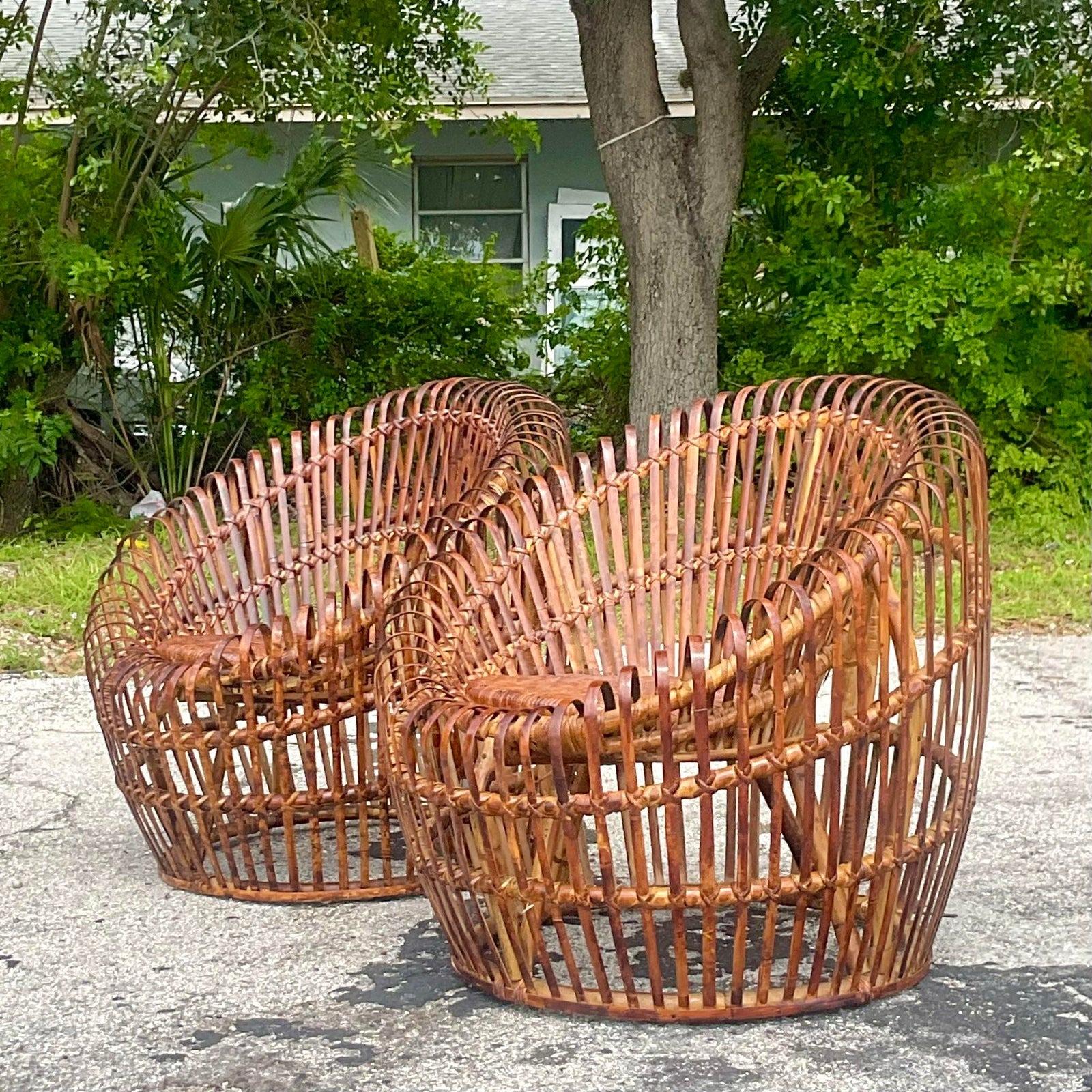 A fabulous pair of vintage Coastal bamboo chairs. Chic strips of bamboo bent into the coveted pod shape. Rich brown tortoise shell finish. Woven rattan seats. Acquired from a Palm Beach estate.