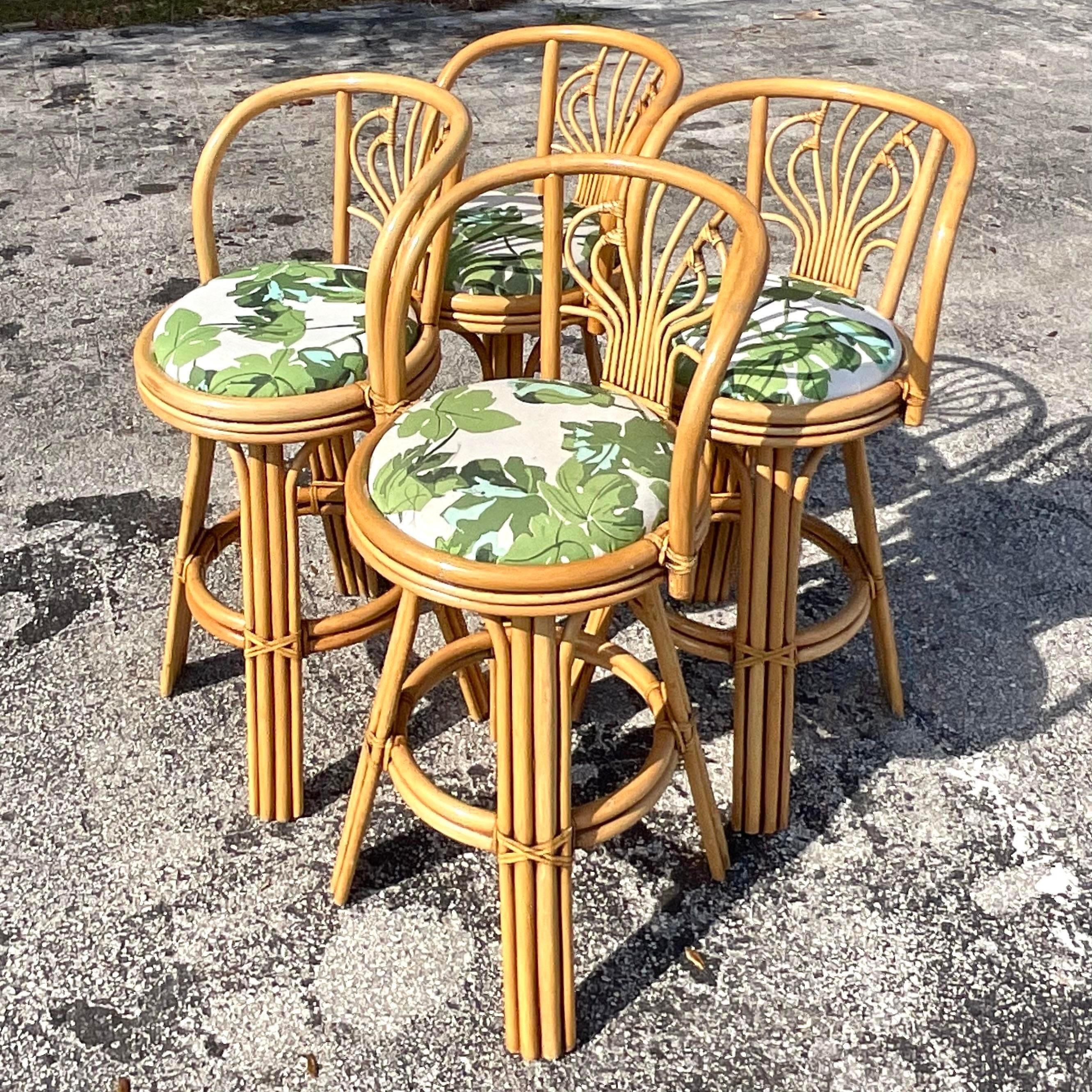 A fabulous set of four vintage Coastal barstools. A chic bent rattan with a fabulous squiggle design on the seat back. Beautiful tropical print upholstery. Acquired from a Palm Beach estate.