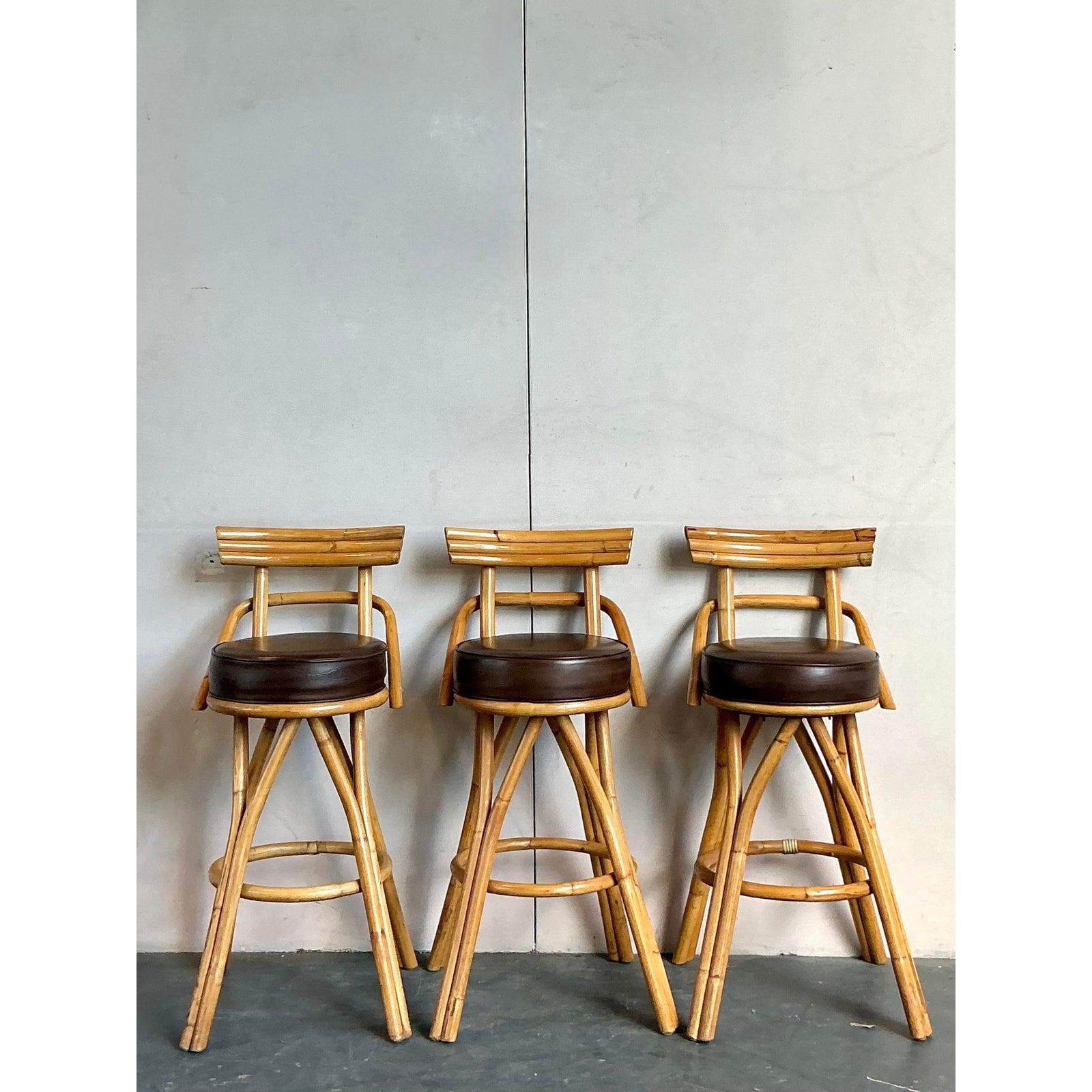 Adoptez une esthétique décontractée mais sophistiquée avec ce charmant ensemble de trois tabourets de bar vintage, présentant un ravissant design en rotin courbé côtier. Chaque tabouret est doté d'une structure en rotin joliment incurvée qui évoque