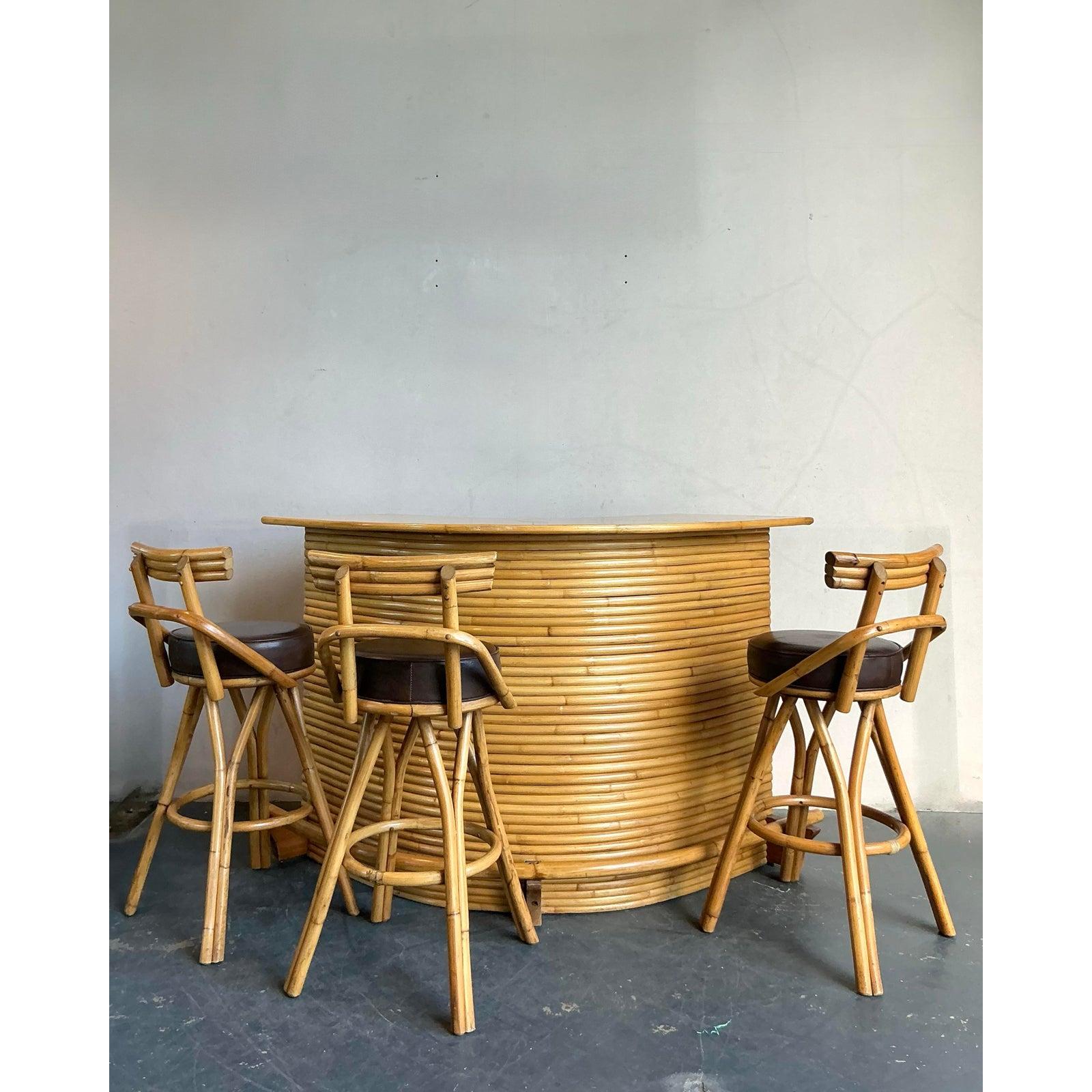Inject a relaxed, vacation-inspired ambiance into your home with this exquisite vintage coastal bent rattan dry bar. This charming piece showcases the artistry of bent rattan, forming a beautifully curved facade that exudes warmth and organic