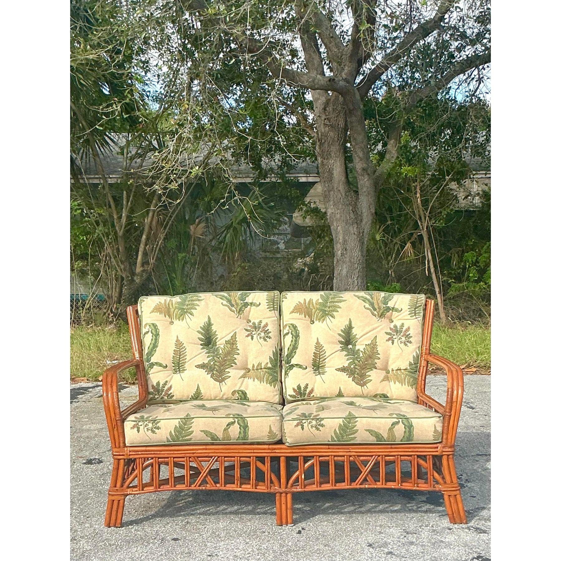 Infunde encanto tropical a tu espacio con este impresionante loveseat vintage de ratán curvado. Con un intrincado armazón de ratán y un cálido acabado en tonos miel, esta pieza encarna la relajada elegancia costera. Los cojines de felpa muestran un