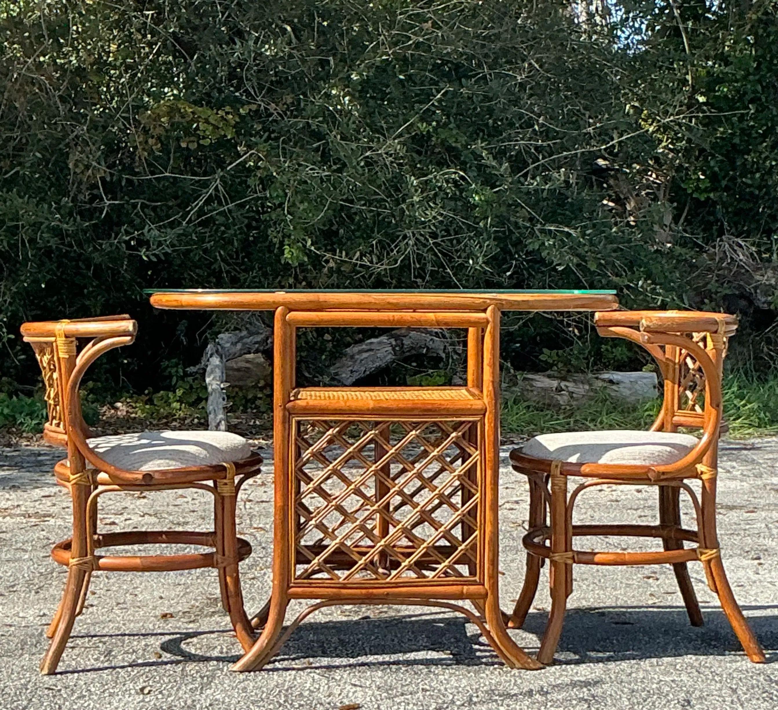 Questo set hollywoodiano in rattan dalla forma vintage e dalla forma costiera emana un glamour senza sforzo e una raffinatezza disinvolta. Caratterizzato da cornici in rattan splendidamente curvate con finiture naturali, questo set cattura l'essenza