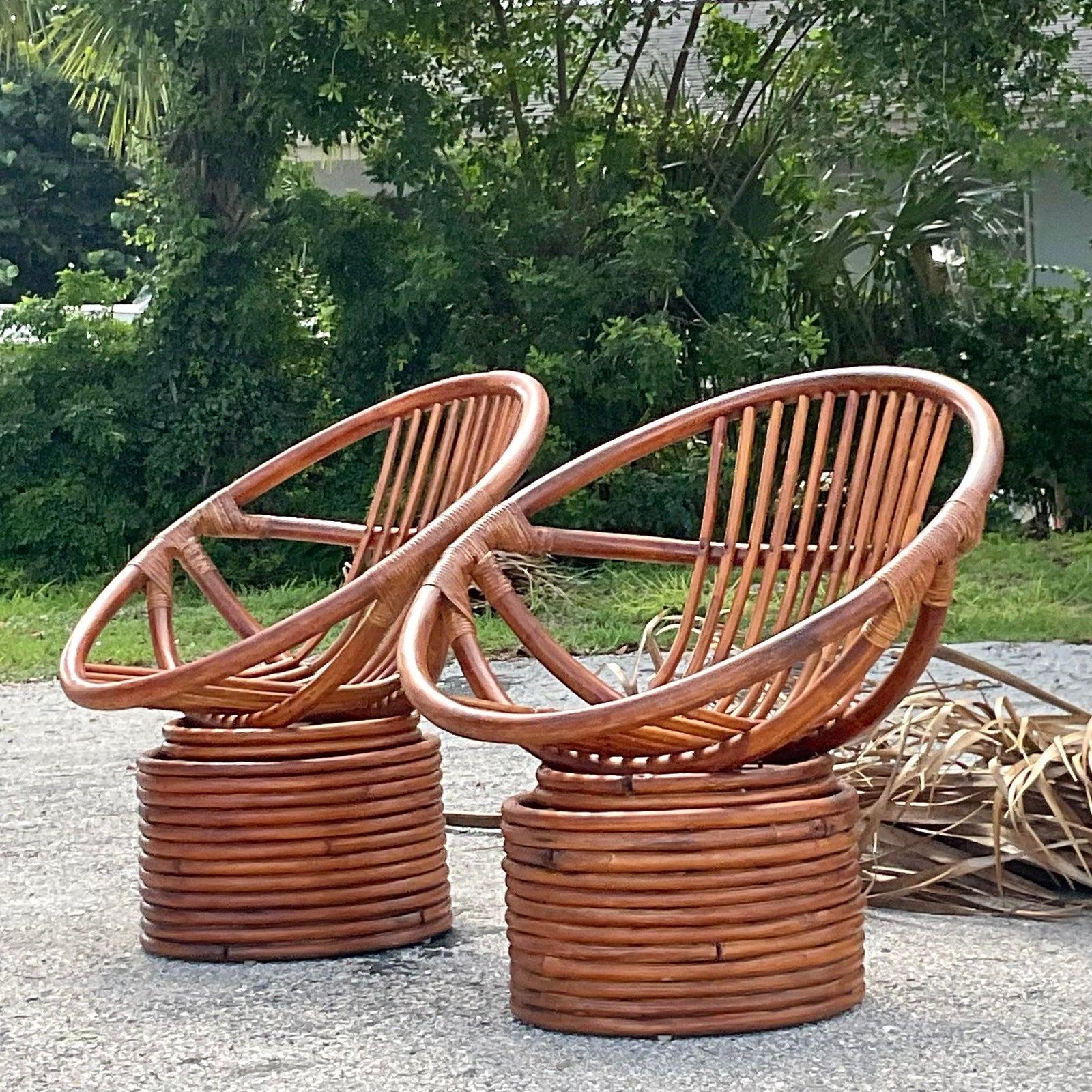A fabulous pair of vintage Coastal swivel chairs. A chic bent rattan in a hoop design. A rich cinnamon brown finish. Acquired from a Palm Beach estate.